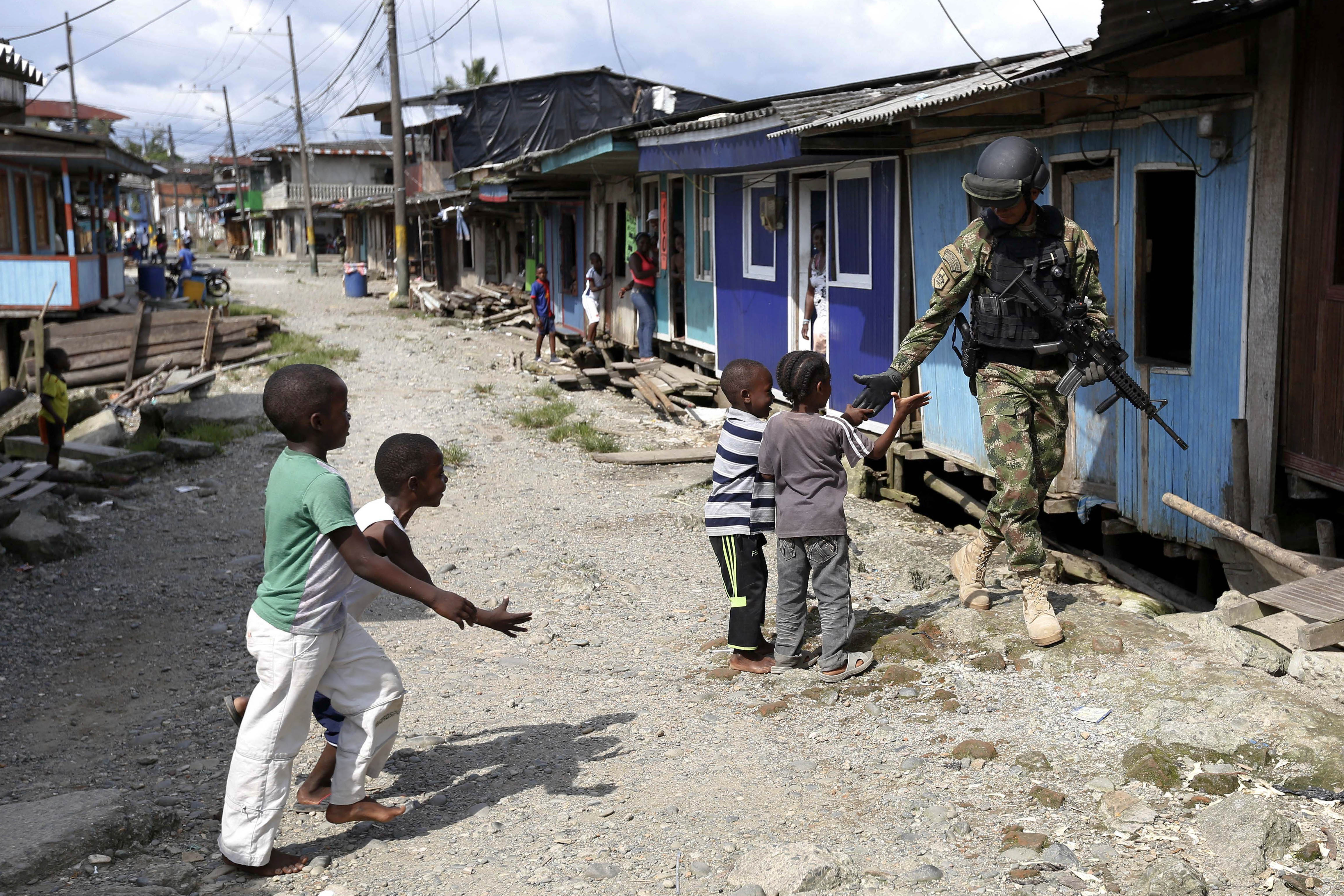 Children greet a member of the Navy Special Forces patrolling La Playita neighbourhood in Buenaventura, March 27, 2014