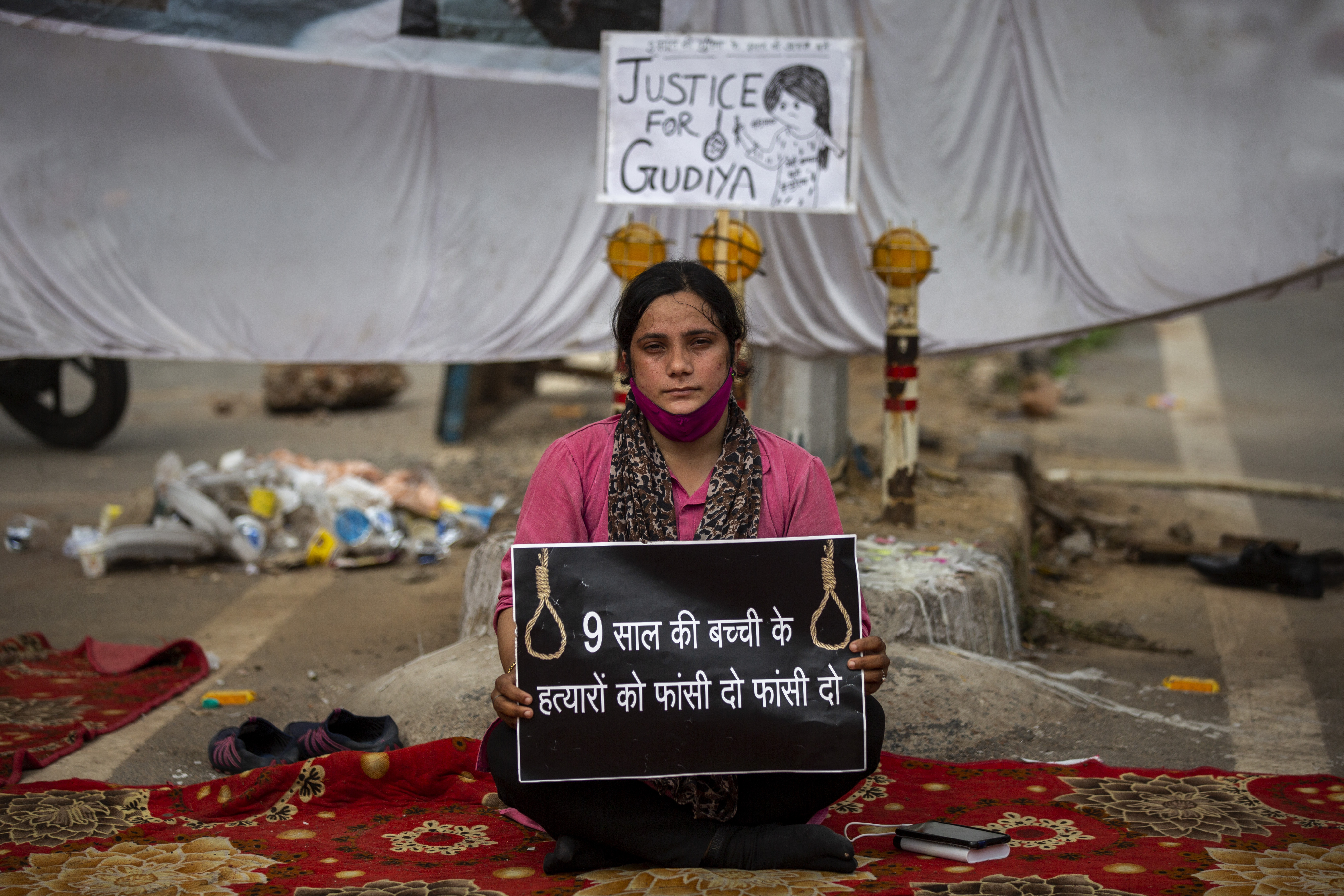 Tina Verma, 27, a social activist, holds a placard that reads ‘Hang the killers of nine-year old child’ at a demonstration