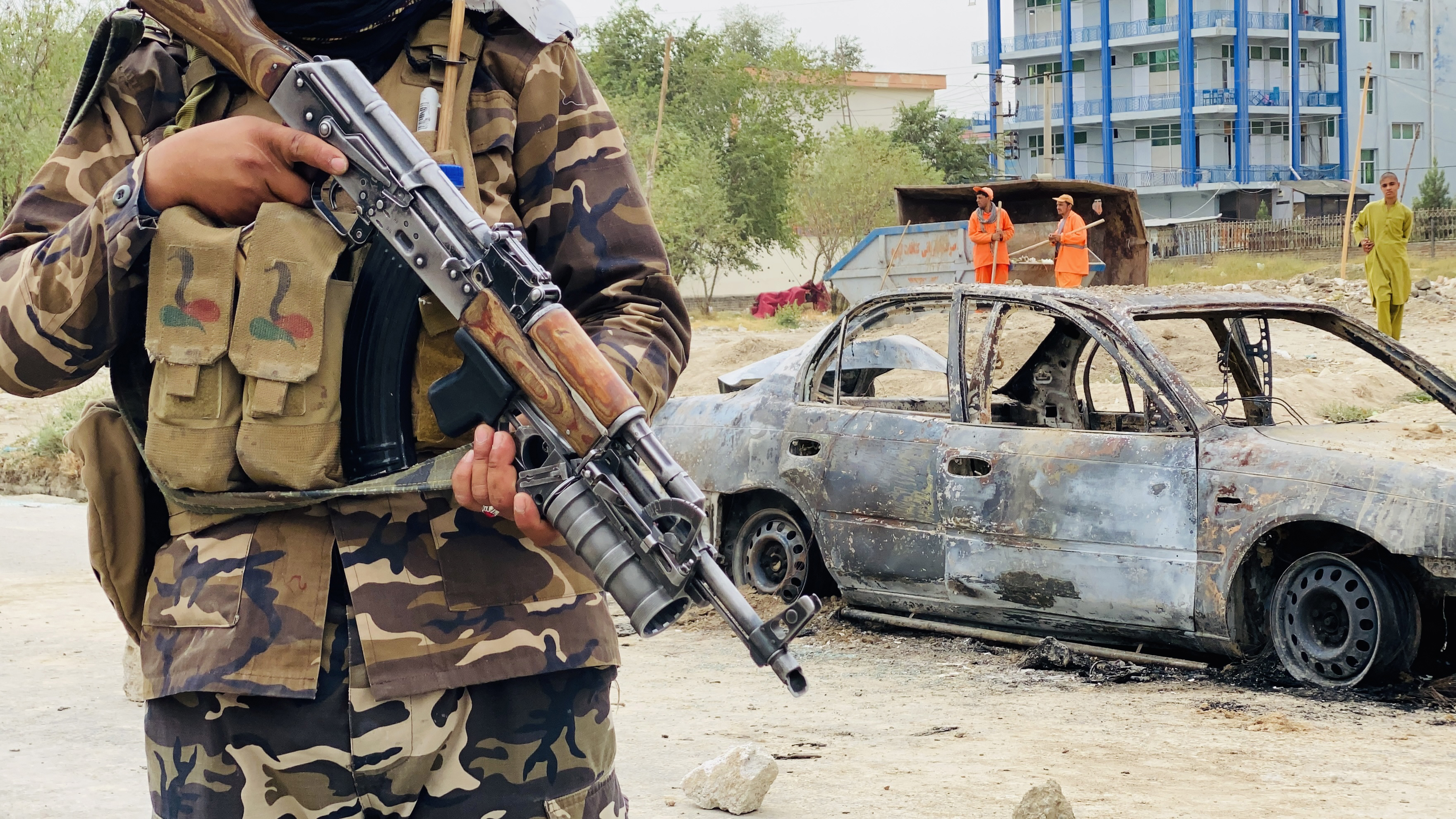 Taliban stands guard near a vehicle that was used to fire rockets at Kabul airport