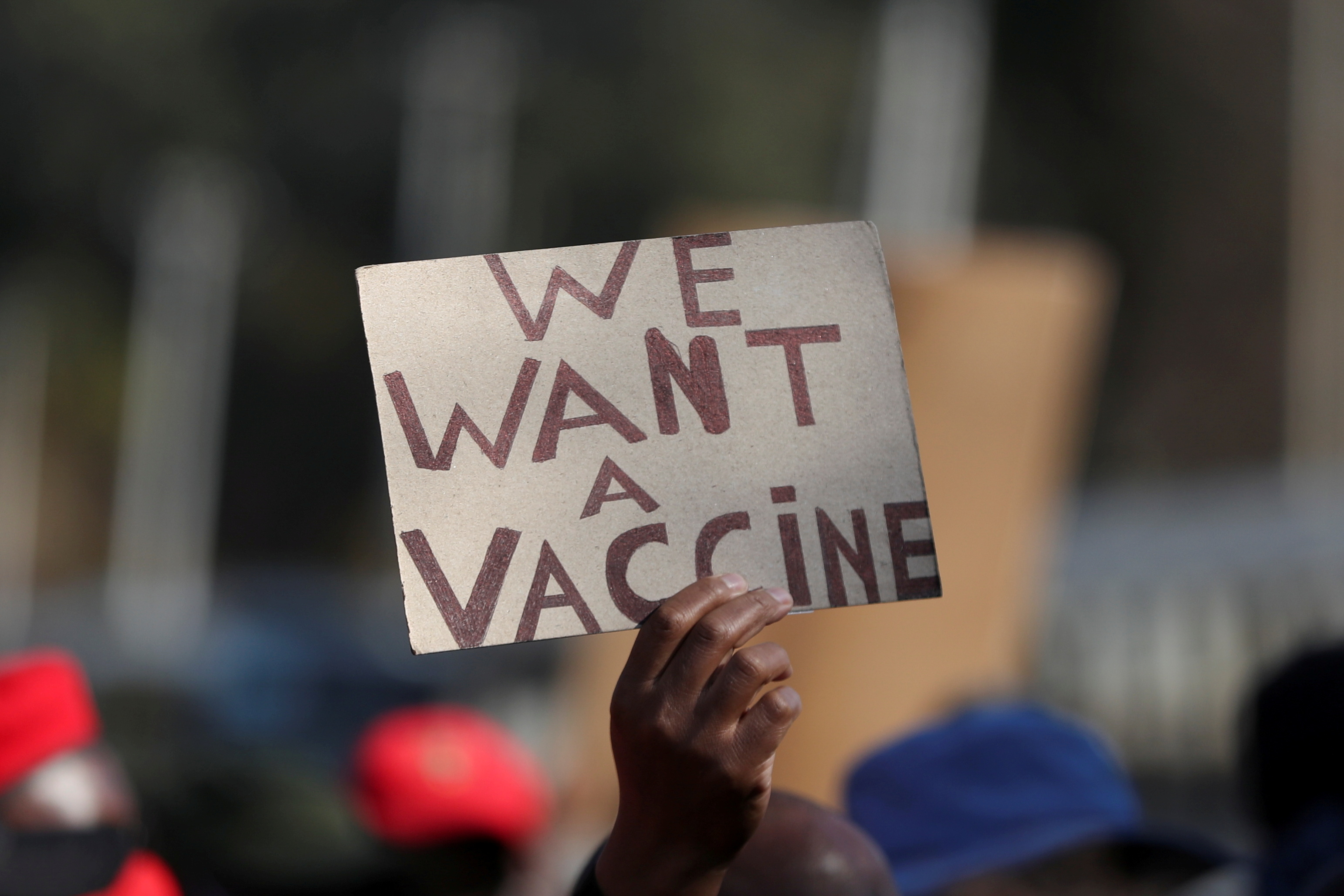 A person holds a placard as supporters of the Economic Freedom Fighters (EFF) march to demand a rollout of coronavirus disease (COVID-19) vaccines, in Pretoria, South Africa June 25, 2021