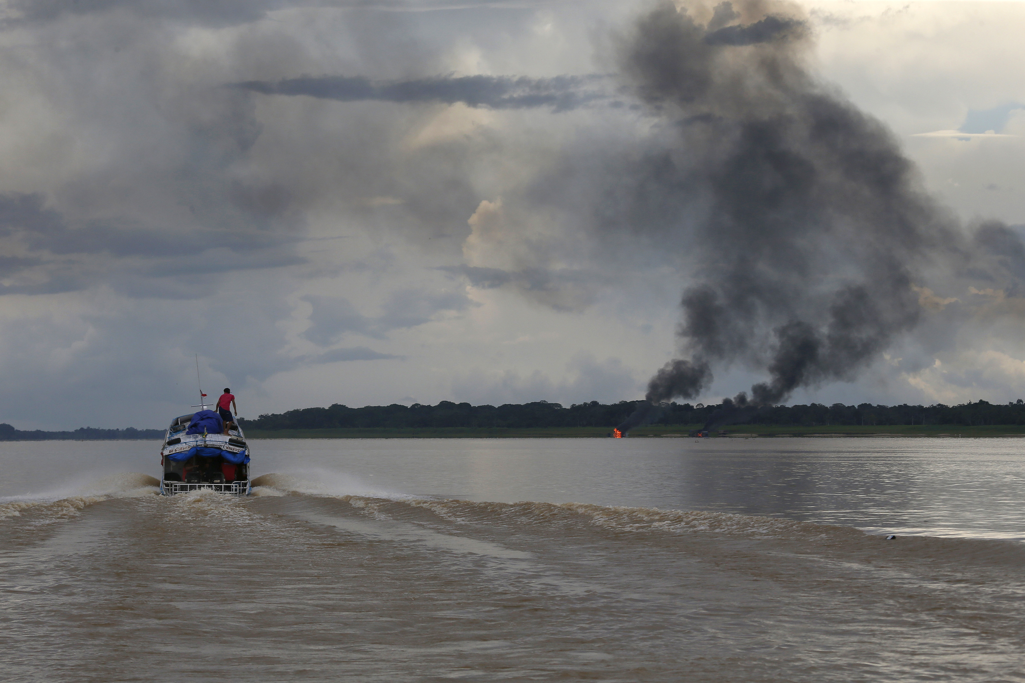 Smoke rises from two dredging barges that were set on fire by IBAMA officers on the Madeira River
