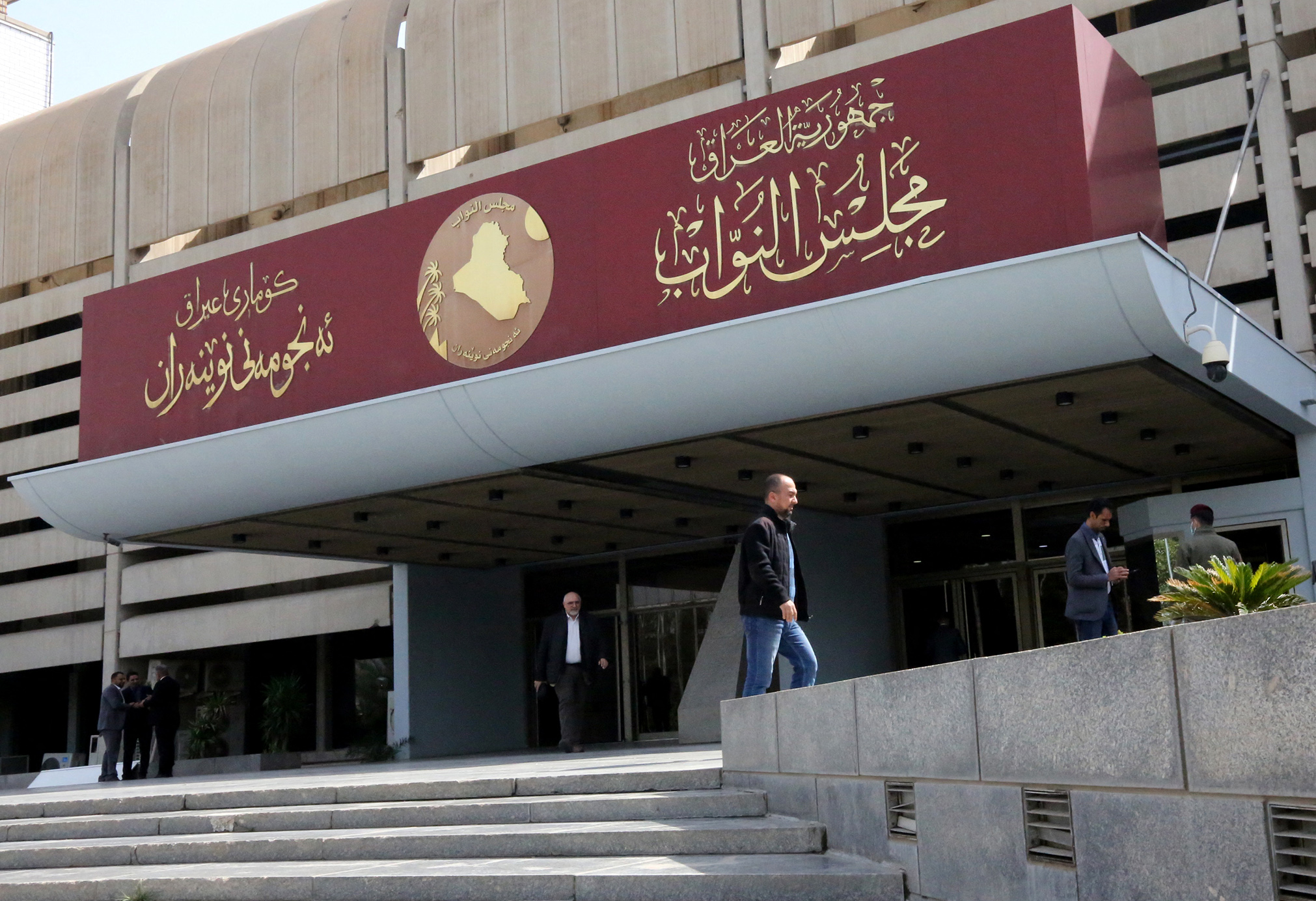 Iraqis stand outside their parliament building, or Council of Representatives, in Baghdad's Green Zone on February 27, 2020.
