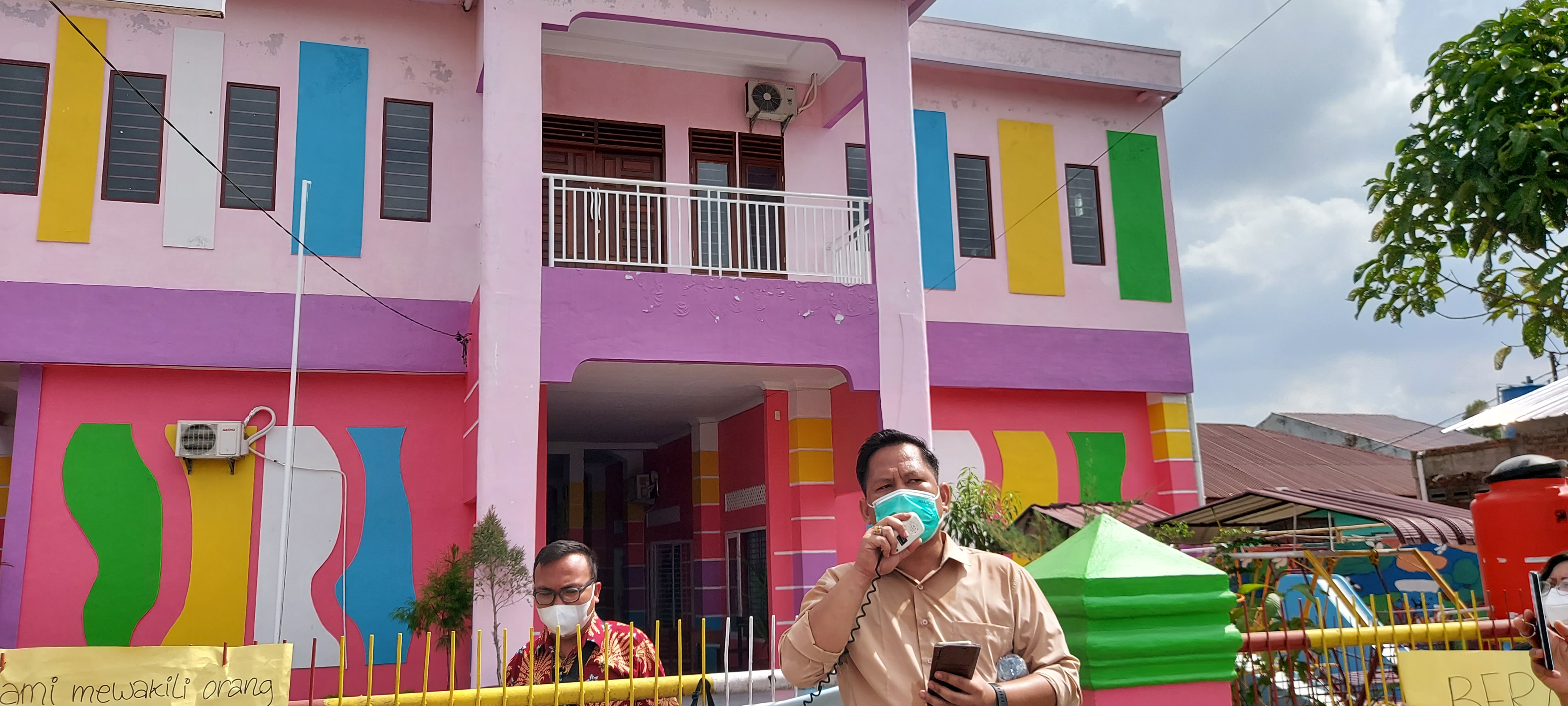 The exterior of the Galilea Hosana school is a mix of pinks, blues, yellows and greens