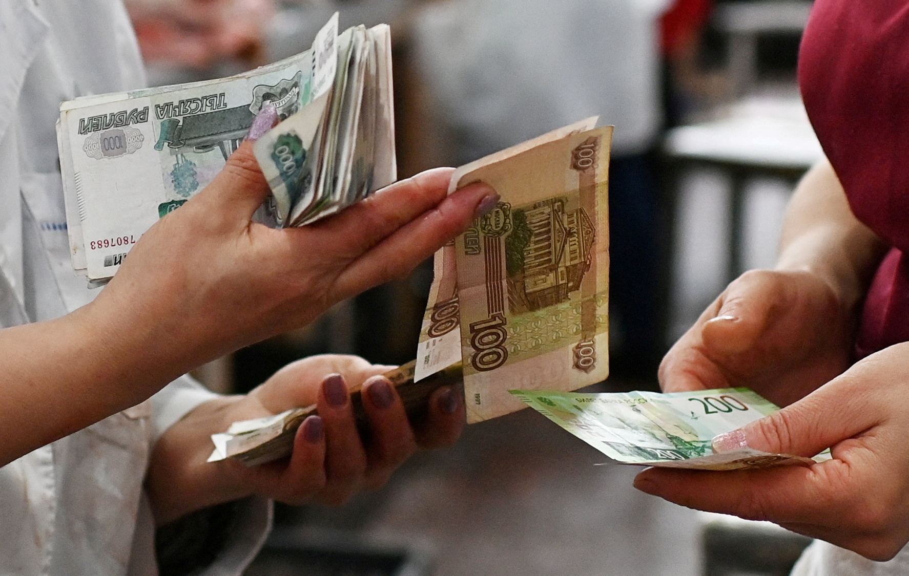 Vendors count Russian ruble banknotes at a market in Omsk