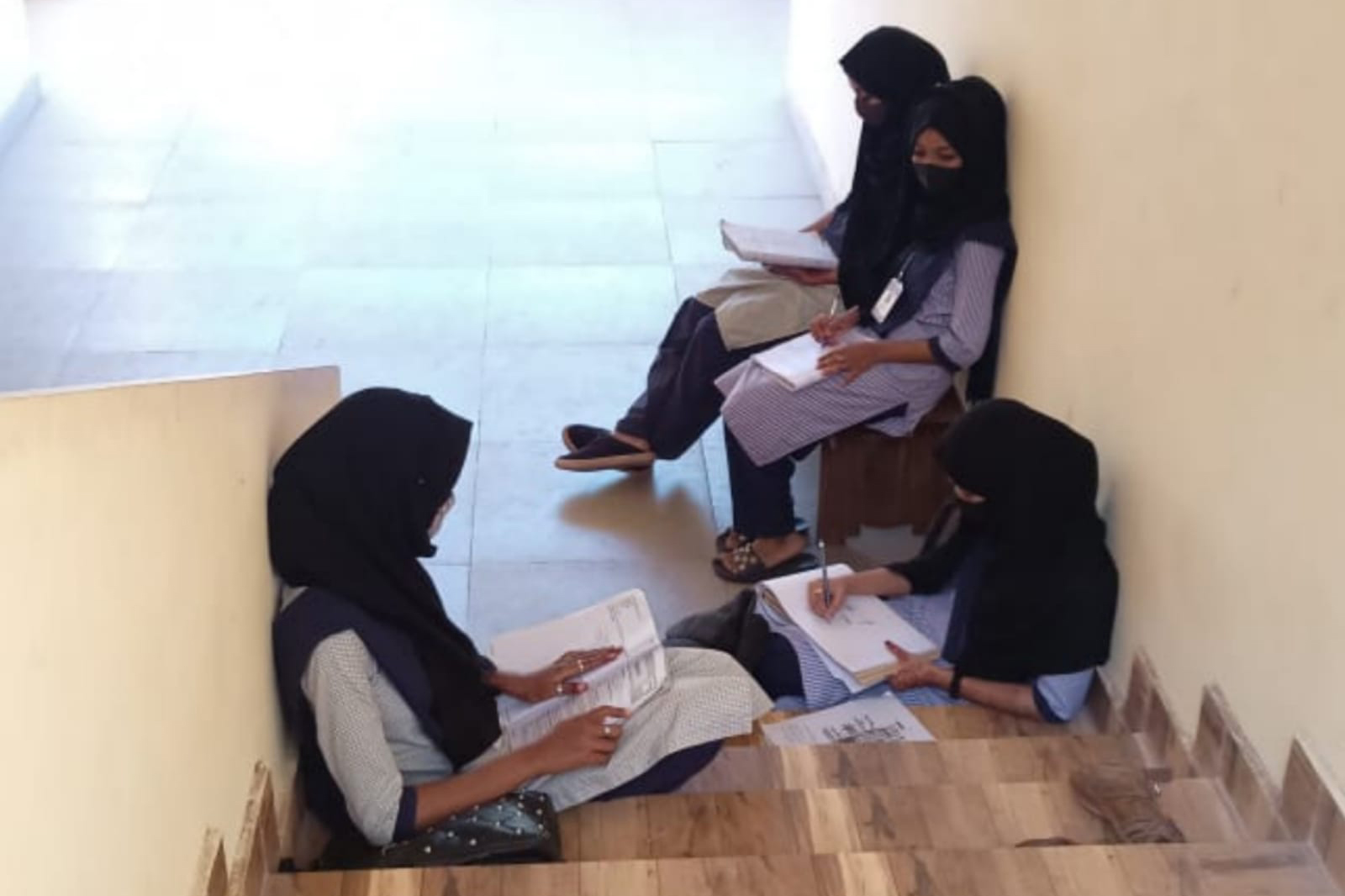 The photo of girls sitting on the stairs of a college in Udupi after they were denied entry into classroom that went viral on social media [Al Jazeera]
