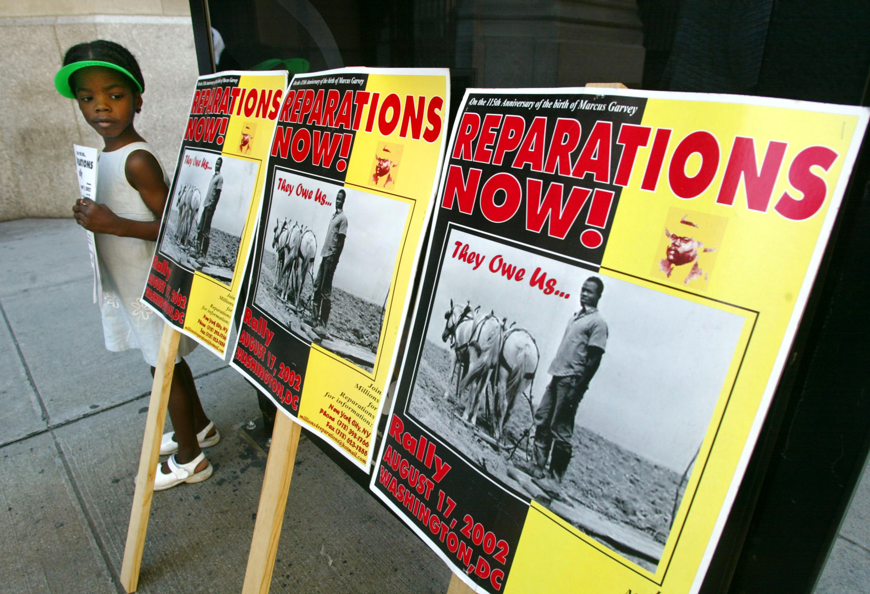 Black girl in a white dress stands next to sign that reads "Reparations now!"