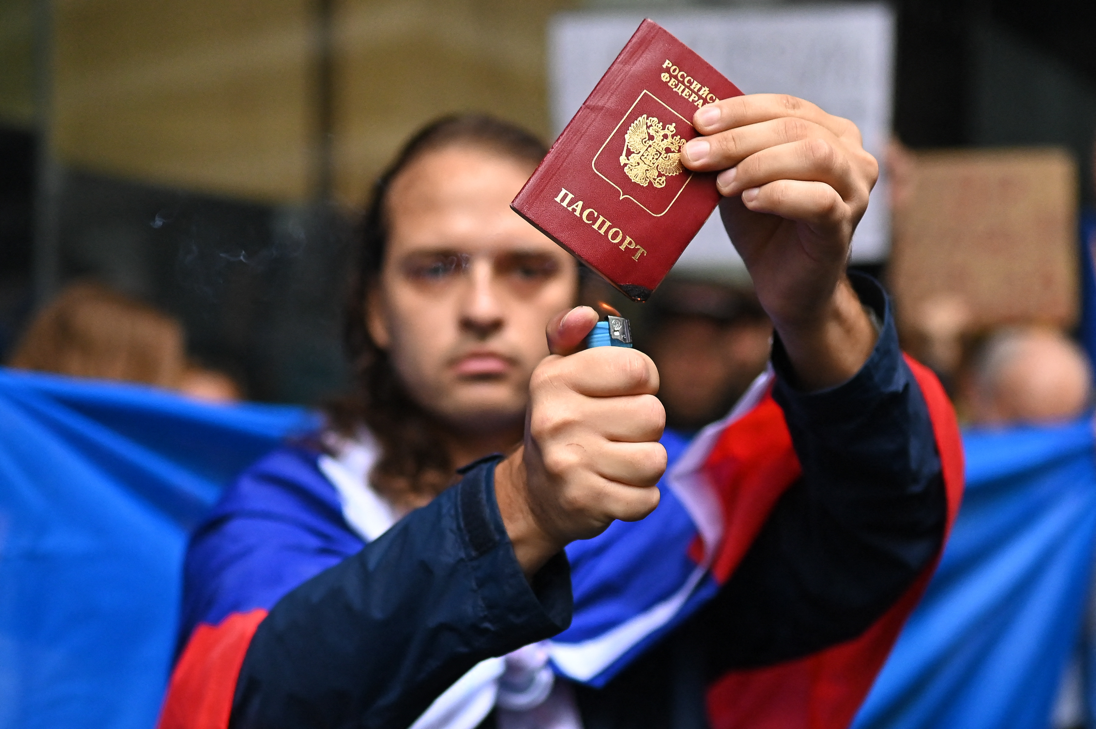 A Russian man burns his passport during a protest against Russia's invasion of Ukraine