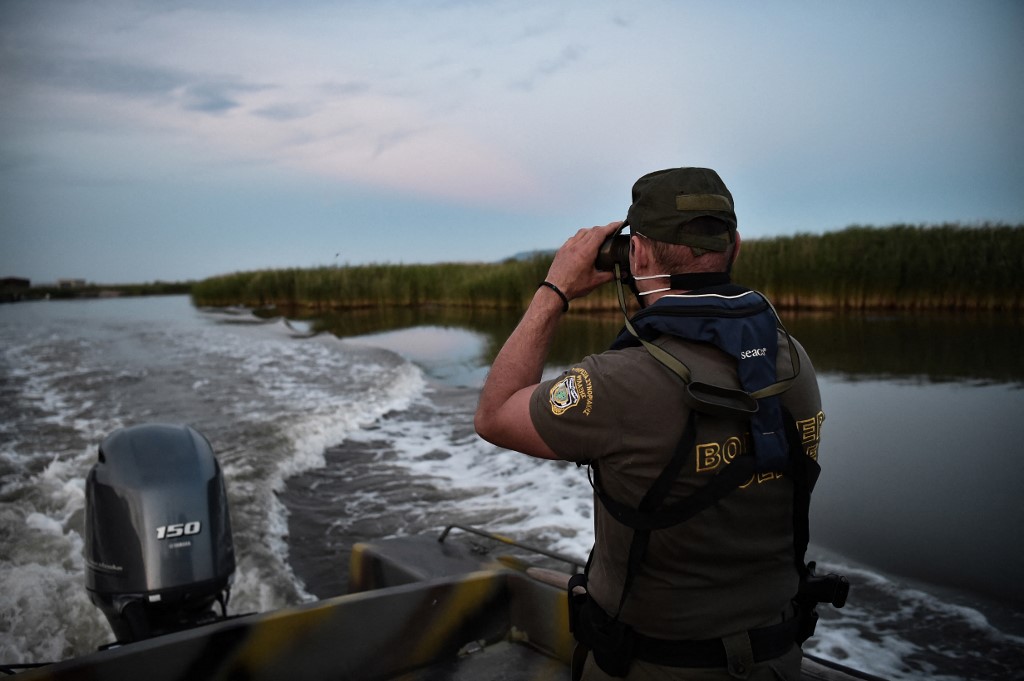 A Greek police officer patrols the delta of Evros River on a boat near Alexandroupoli along the Greek-Turkish border