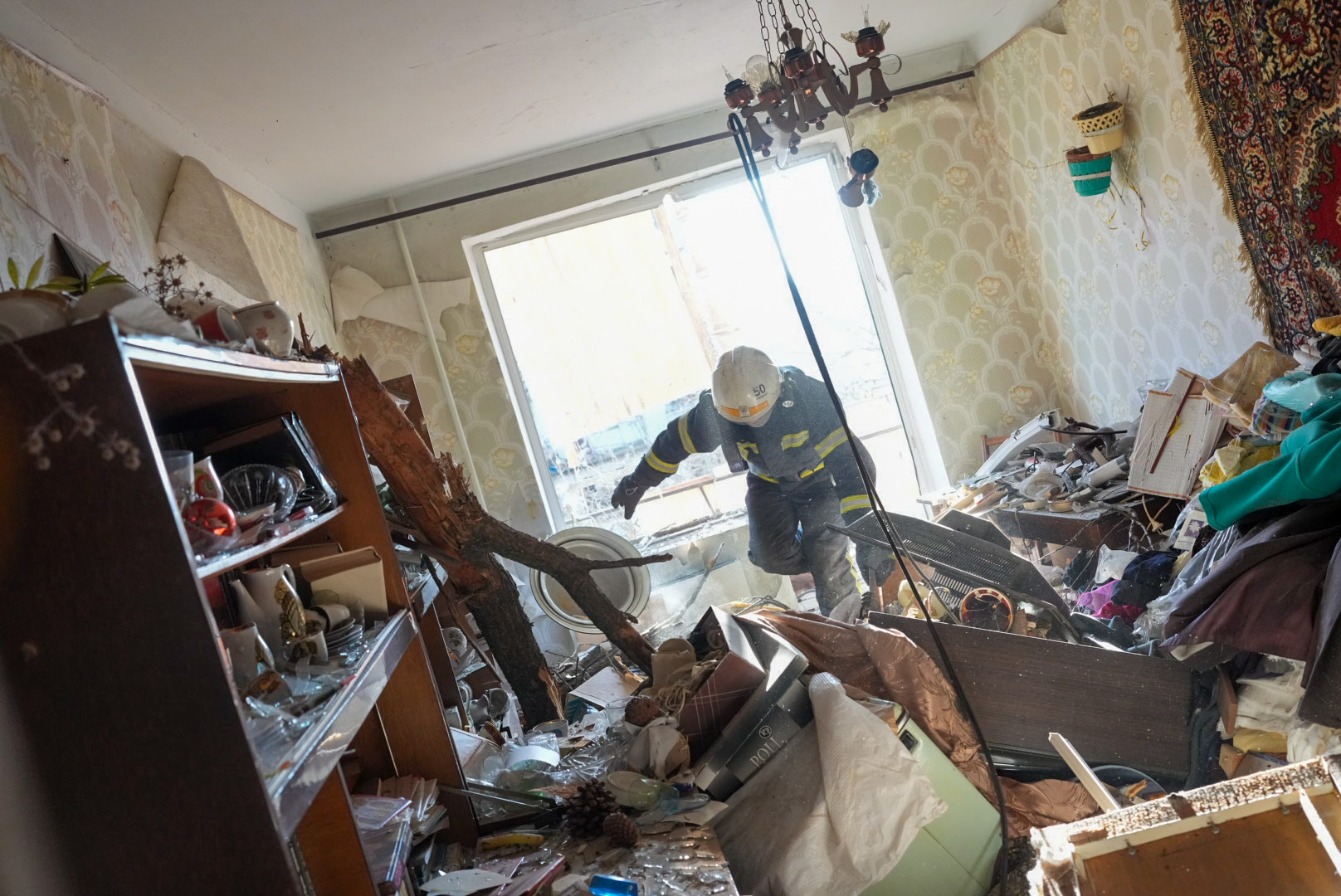Ukrainian firefighters arrive to rescue civilians after an airstrike hit an apartment complex in Chuhuiv