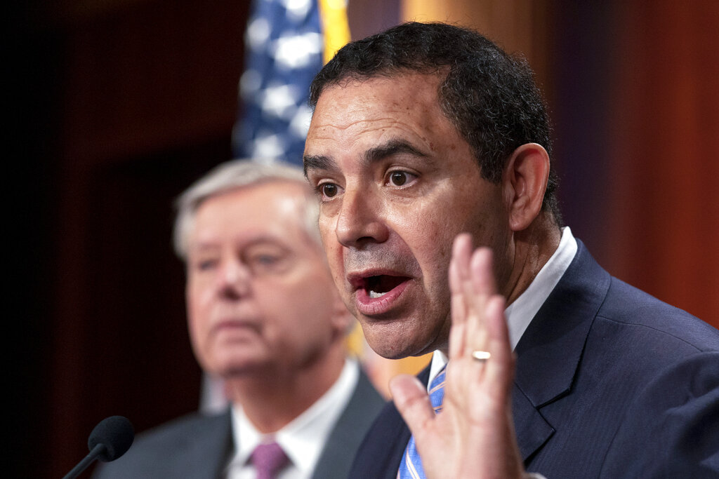Representative Henry Cuellar, D-Texas, with Sen. Lindsey Graham, R-S.C., speaks about the United States-Mexico border during a news conference.