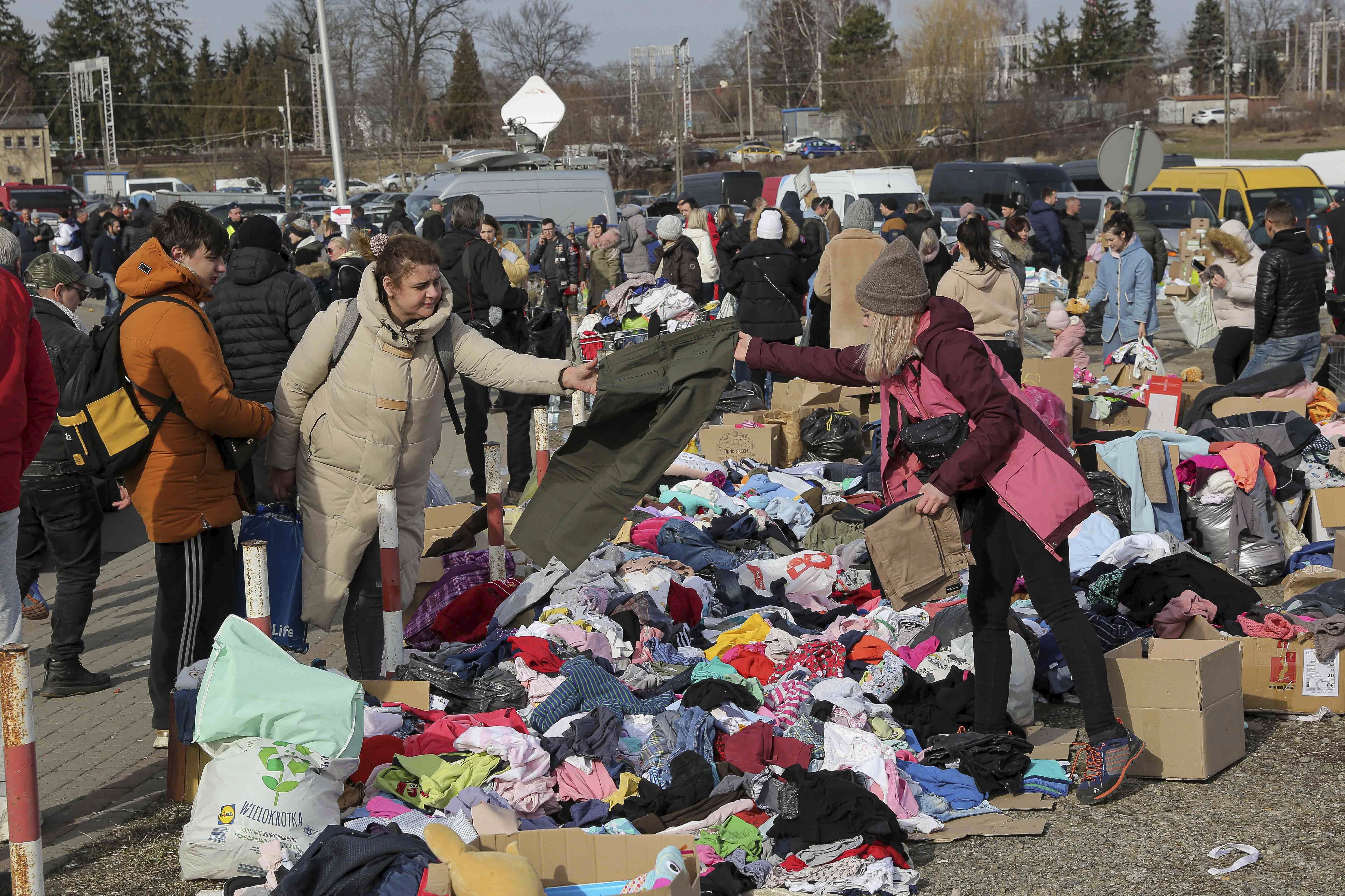 Ukranian refugees are offered warm clothes as they arrive at the Medyka border crossing, in Medyka, Poland