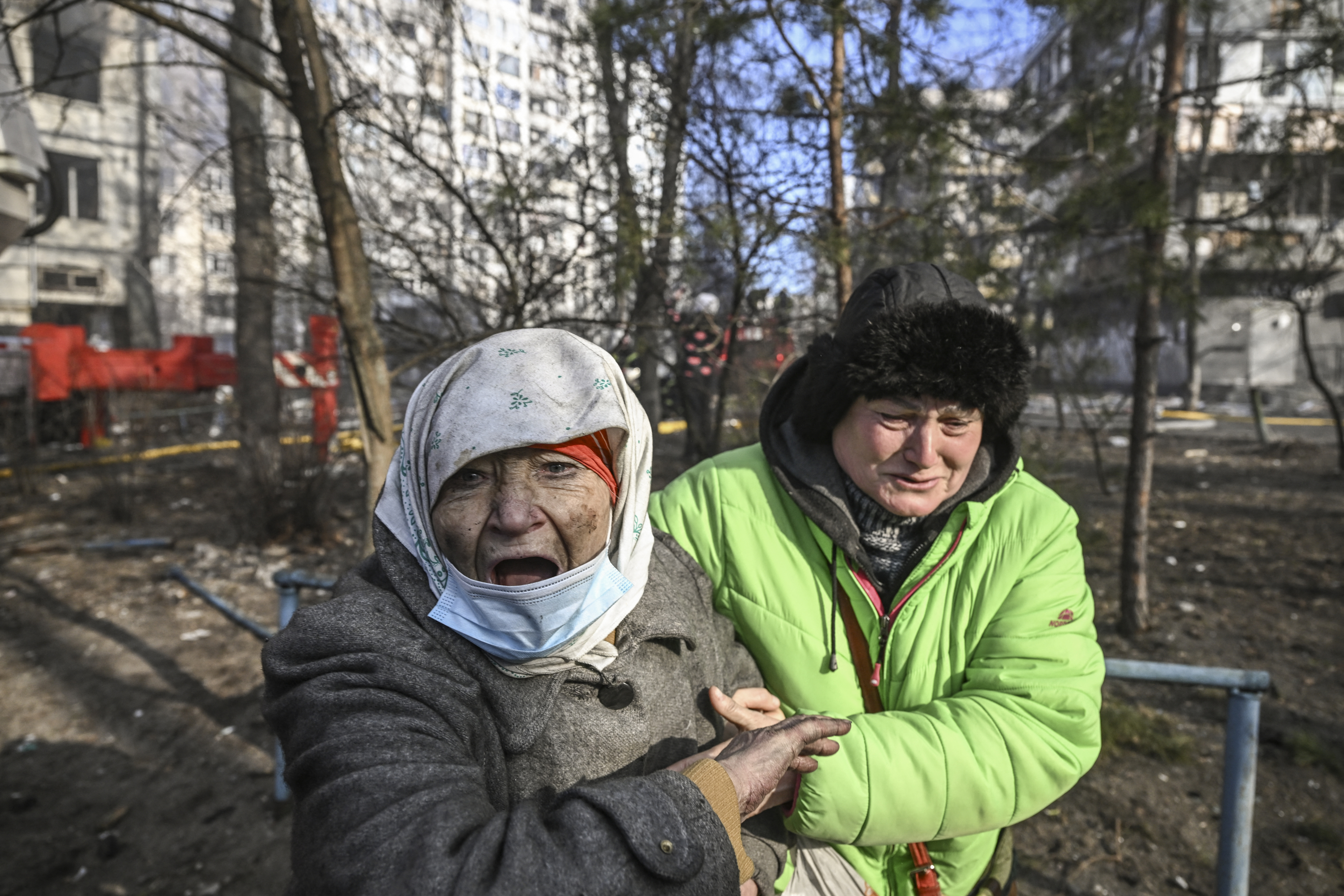 A woman is evacuated from a burning apartment building in Kyiv
