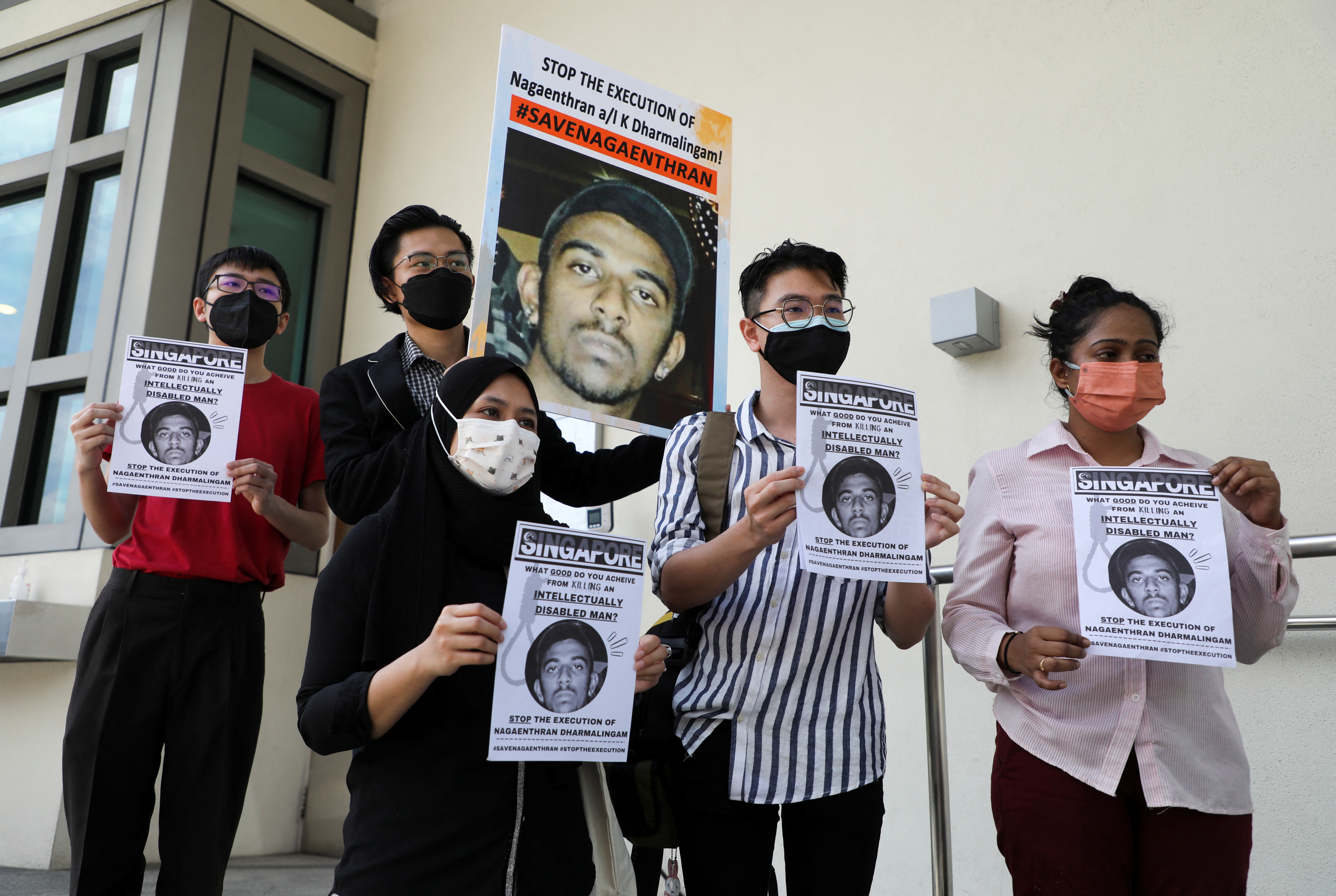 Activists hold posters against the execution of Nagaenthran Dharmalingam