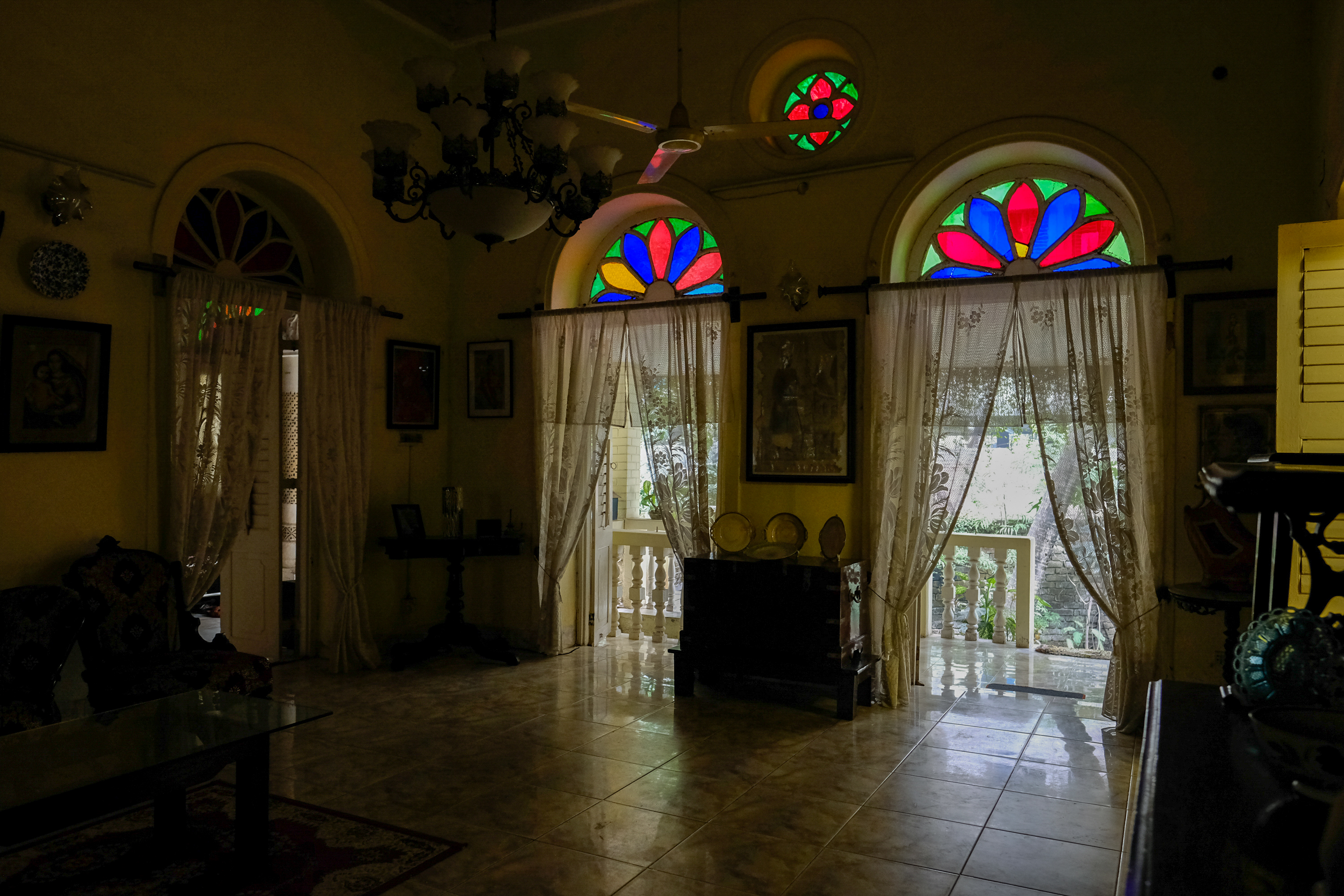 Sunlight glows softly through the stained glass transomed doors leading out to the terrace and garden