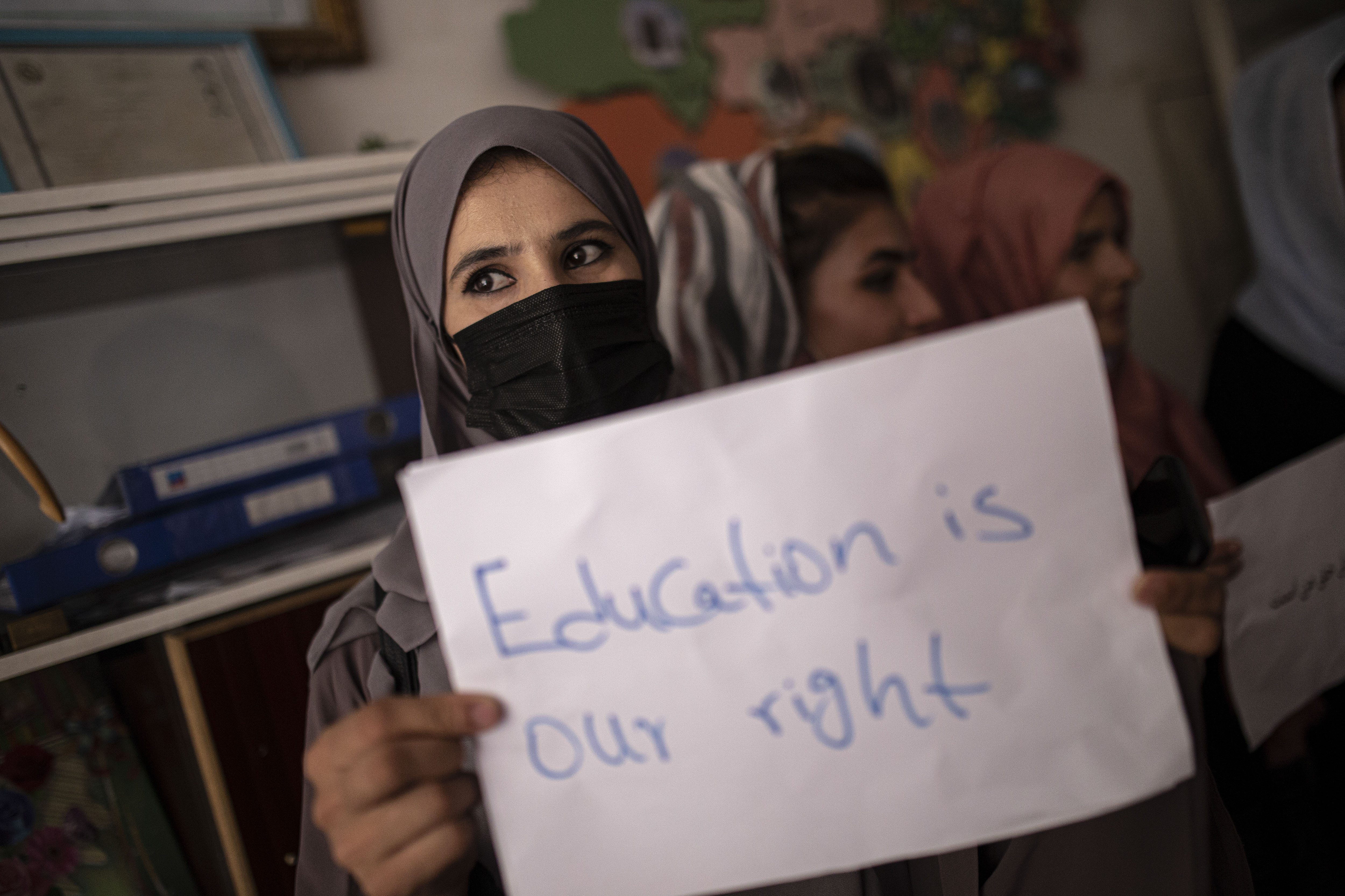 Women, teachers and students demonstrate inside a private school during a gathering for National Teachers Day, in Kabul, Afghanistan