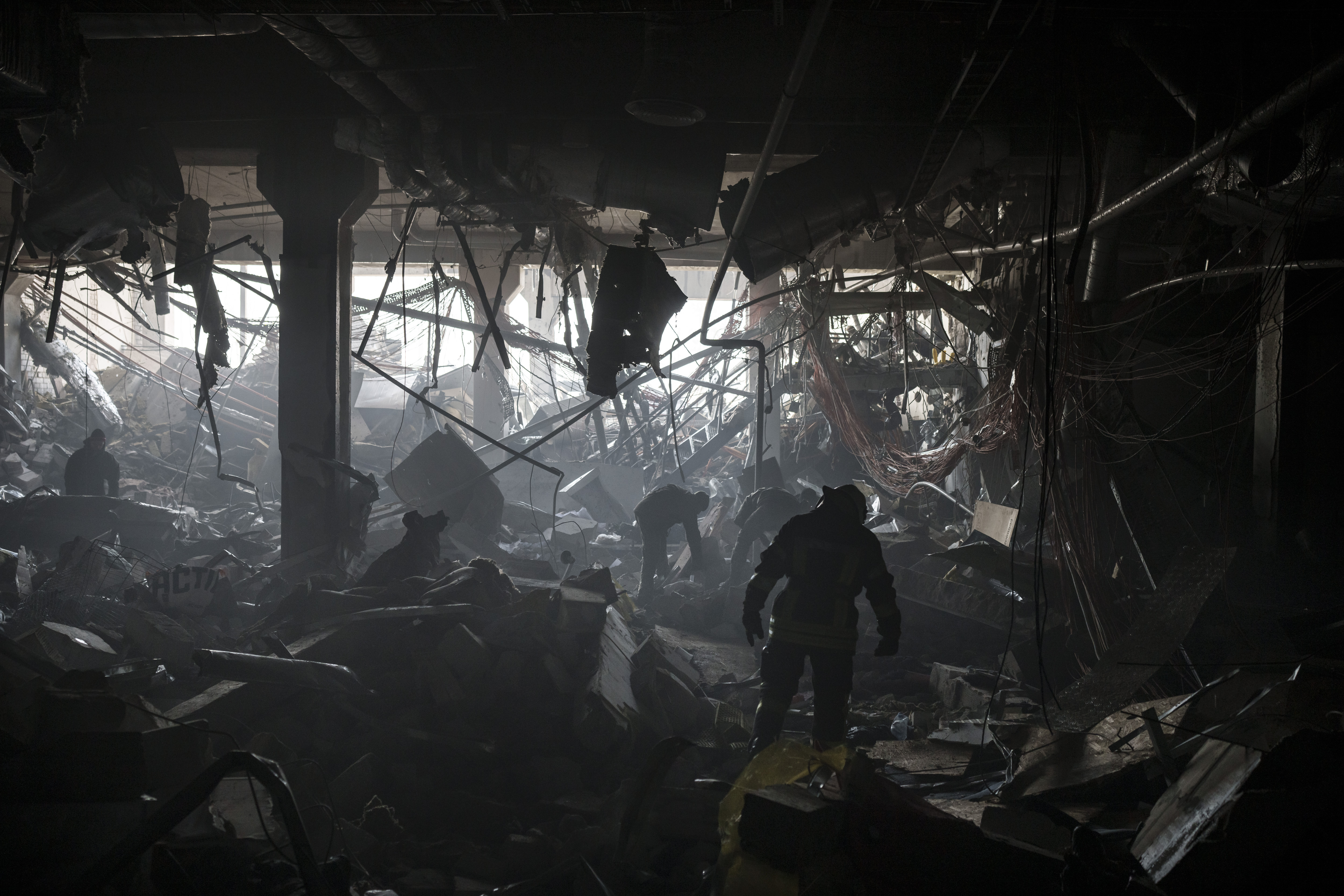 Ukrainian firefighters and servicemen search for people under debri