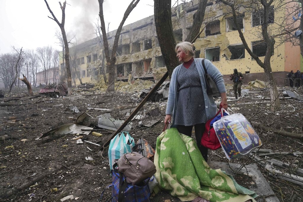A woman walks outside a maternity hospital that was damaged by shelling in Mariupol, Ukraine, on March 9