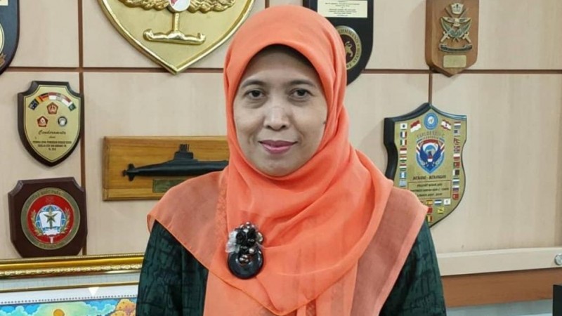 Badriyah Fayumi in a black top with orange headscarf
