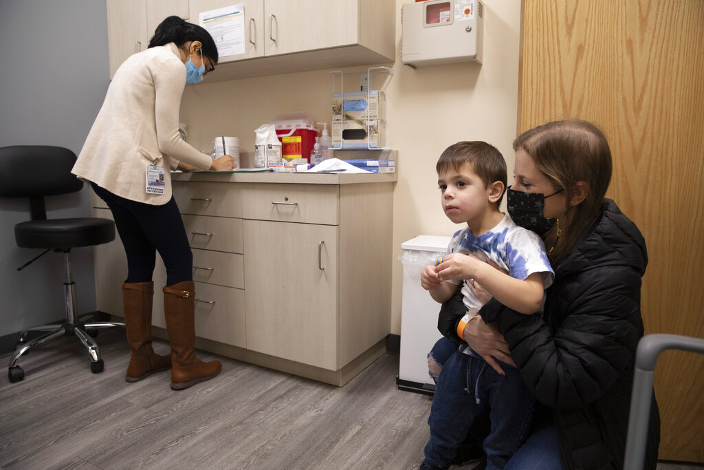 Ilana Diener holds her son, Hudson, 3, during an appointment for a Moderna COVID-19 vaccine trial in Commack, NY, in November