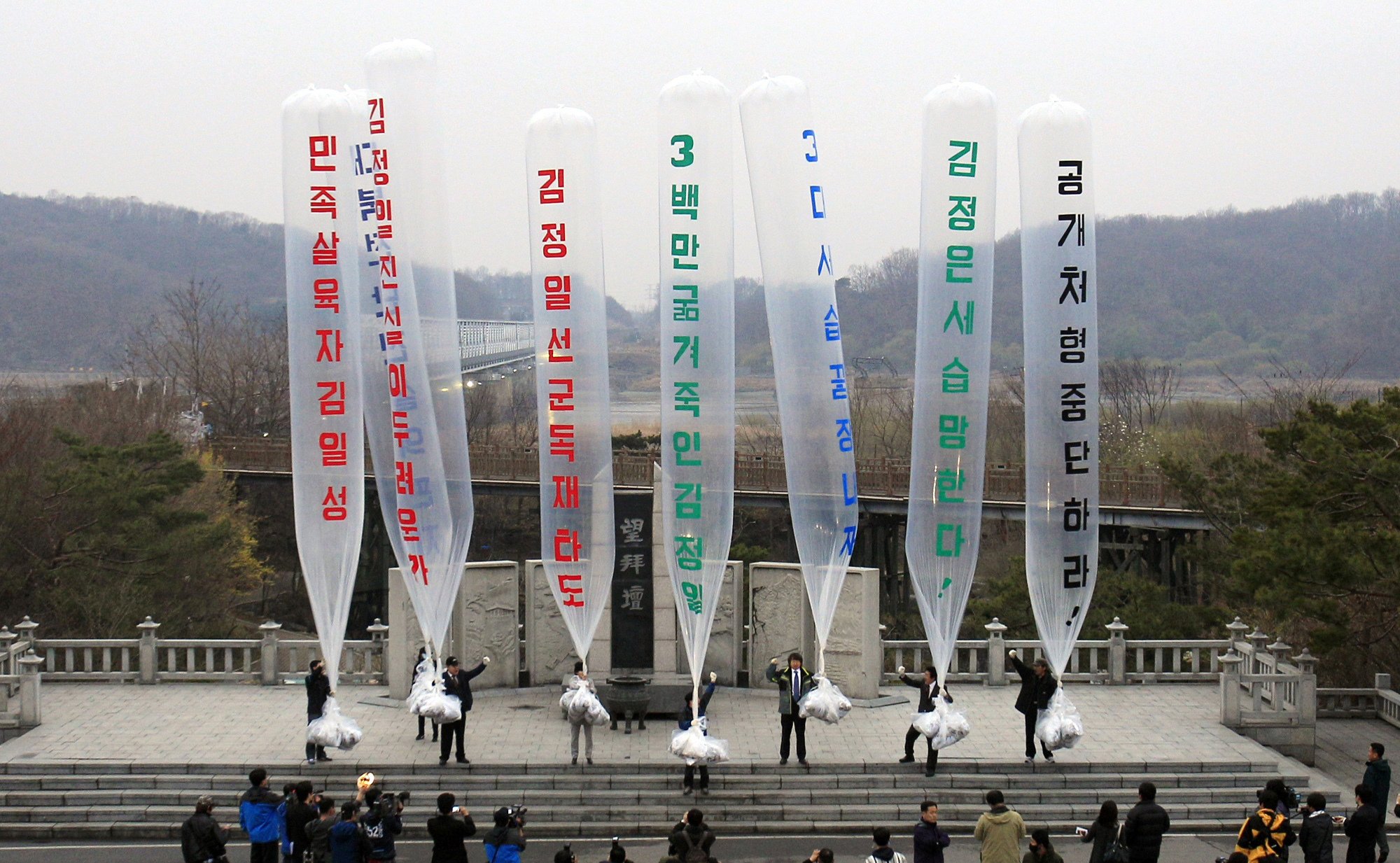 Park Sang-hak, center, a refugee from the North who now runs the group Fighters for a Free North Korea from a small Seoul office, and South Korean conservative activists prepare to release balloons bearing leaflets condemning North Korean leader during an anti-North Korea rally against "The Day of the Sun," the anniversary of Kim Il Sung's birth 99 years, at the Imjingak Pavilion near the border village of Panmunjom in Paju, South Korea. Park said Friday, April 30, 2021, he launched 500,000 propaganda leaflets by balloon into North Korea this week in defiance of a contentious new law that criminalizes such actions. The balloons read "Overthrow Kim Jong Il's dictatorship." (AP Photo/Lee Jin-man, file)