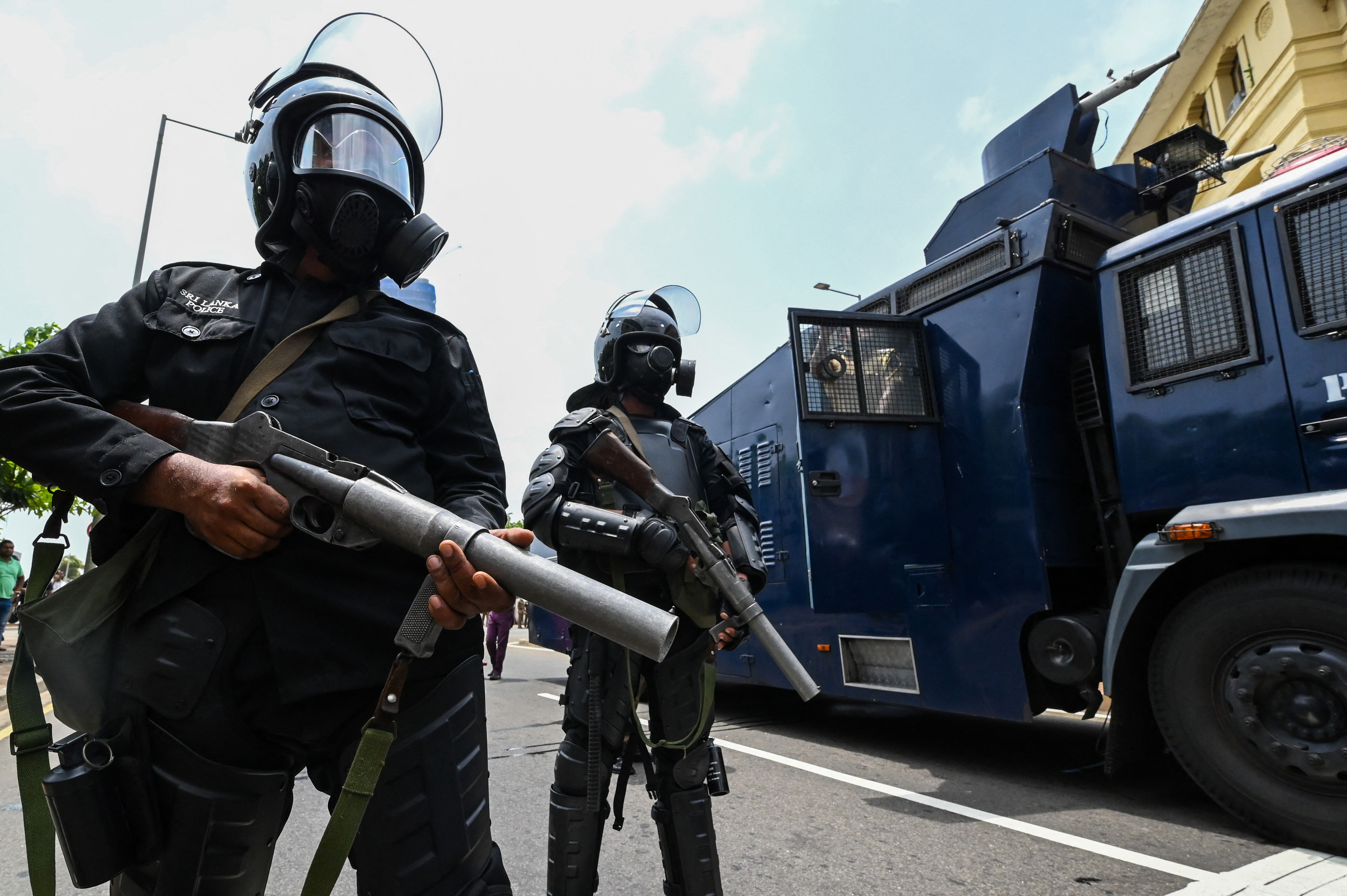 Armed police in body armour stand outside the president's office in Colombo