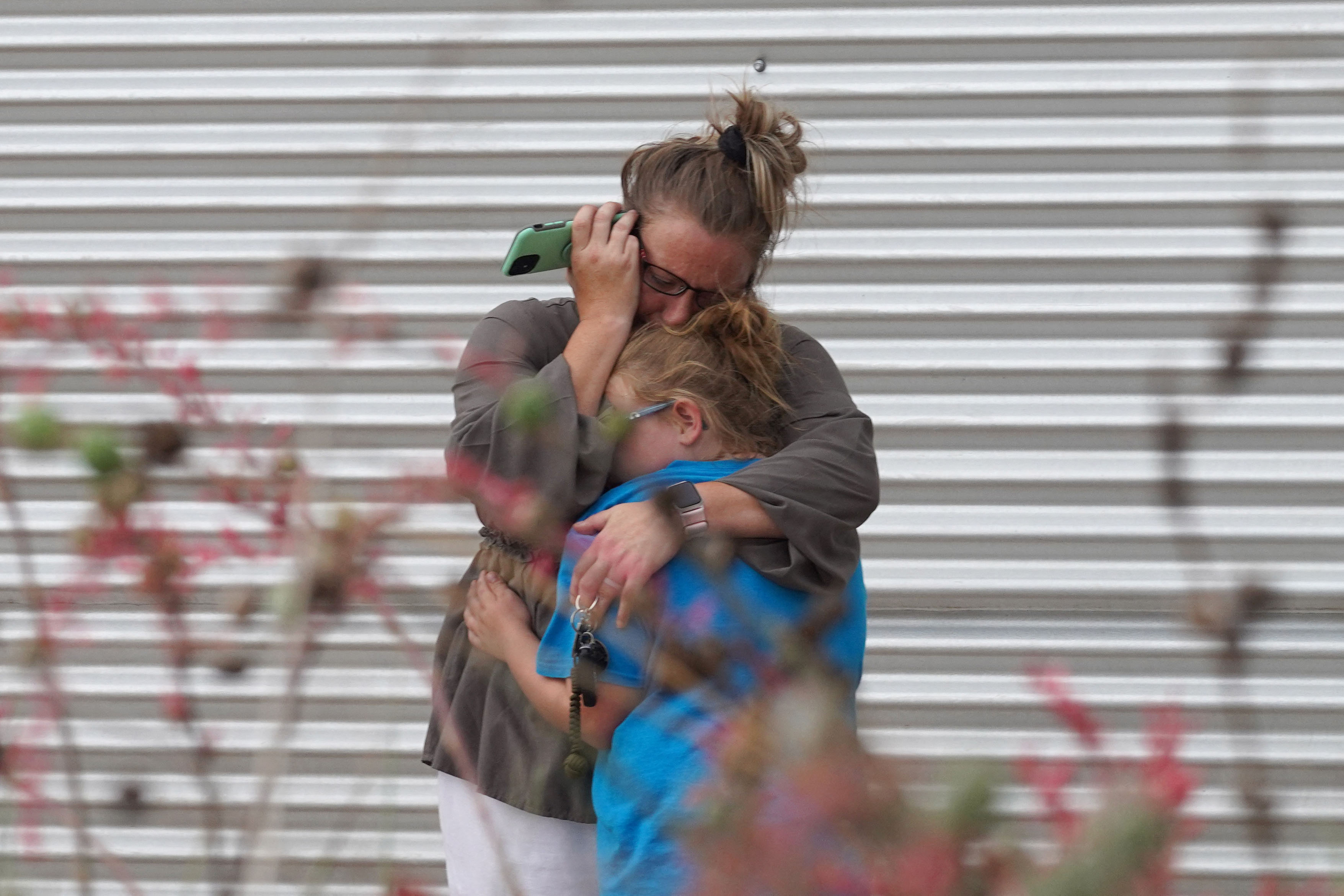 A woman cries and hugs a young girl