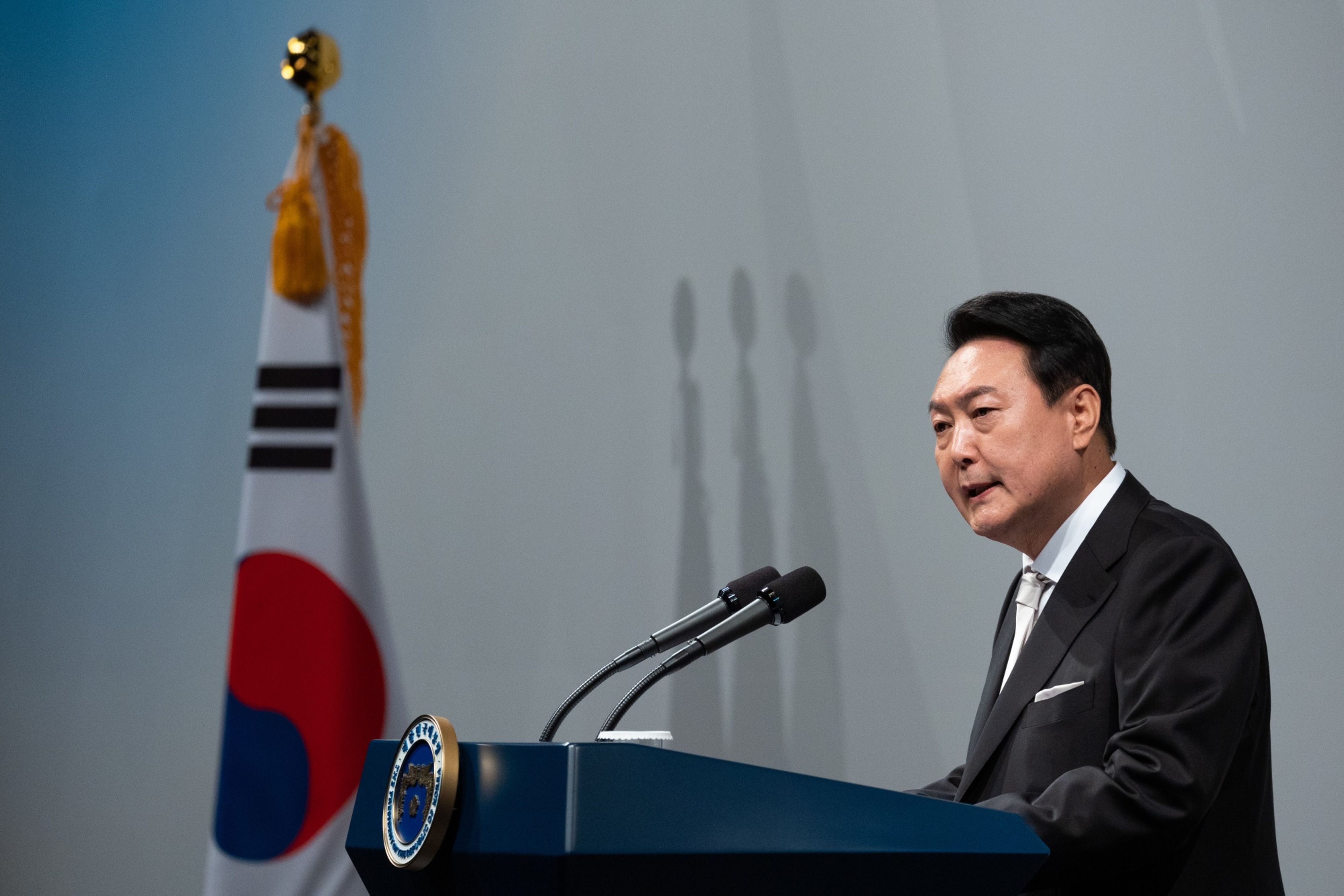 Yoon Suk-yeol talking at a podium.