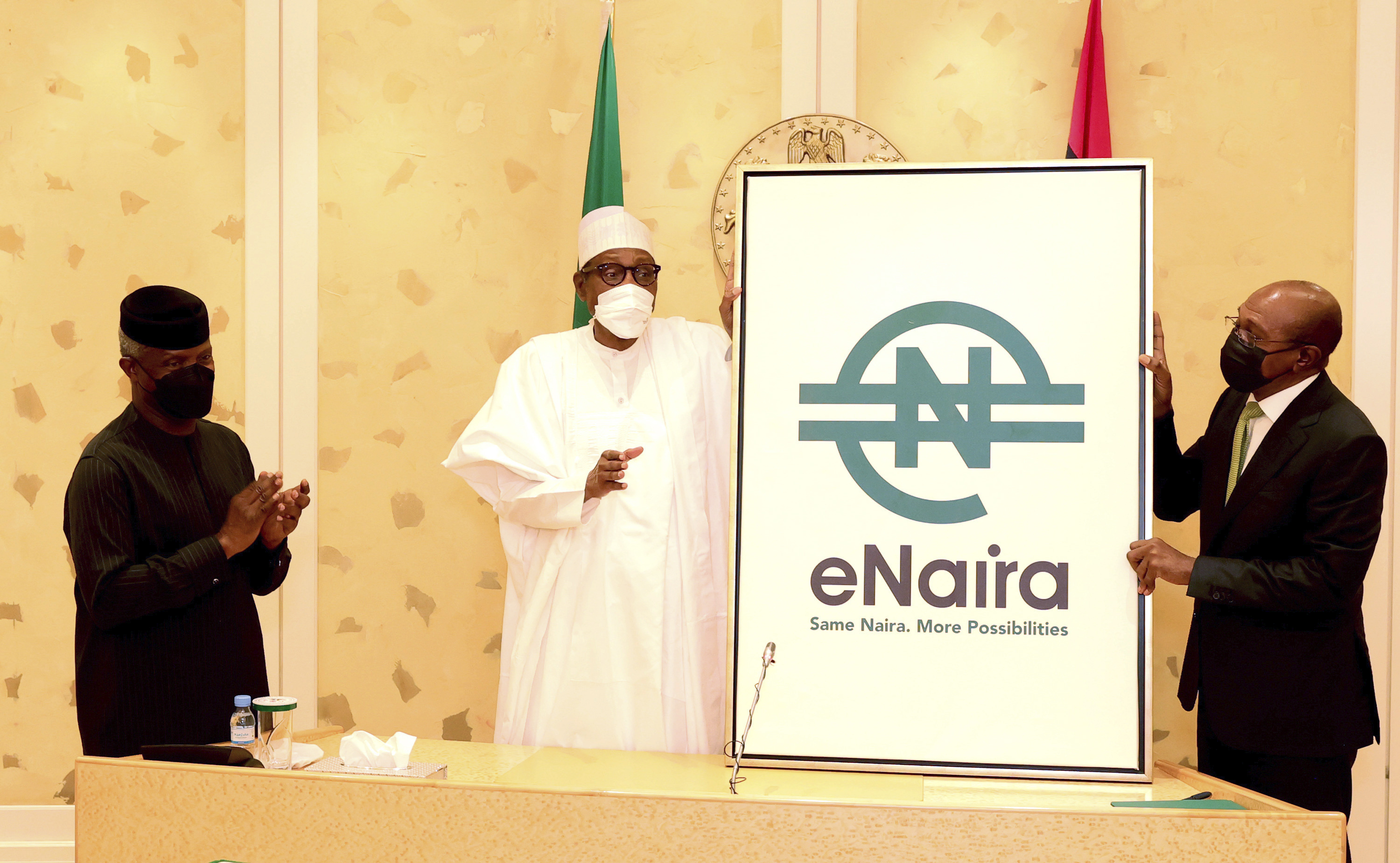 Nigerian President Muhammadu Buhari, centre, and Central Bank governor Godwin Emefiele, right, during the launch of a digital currency in Abuja