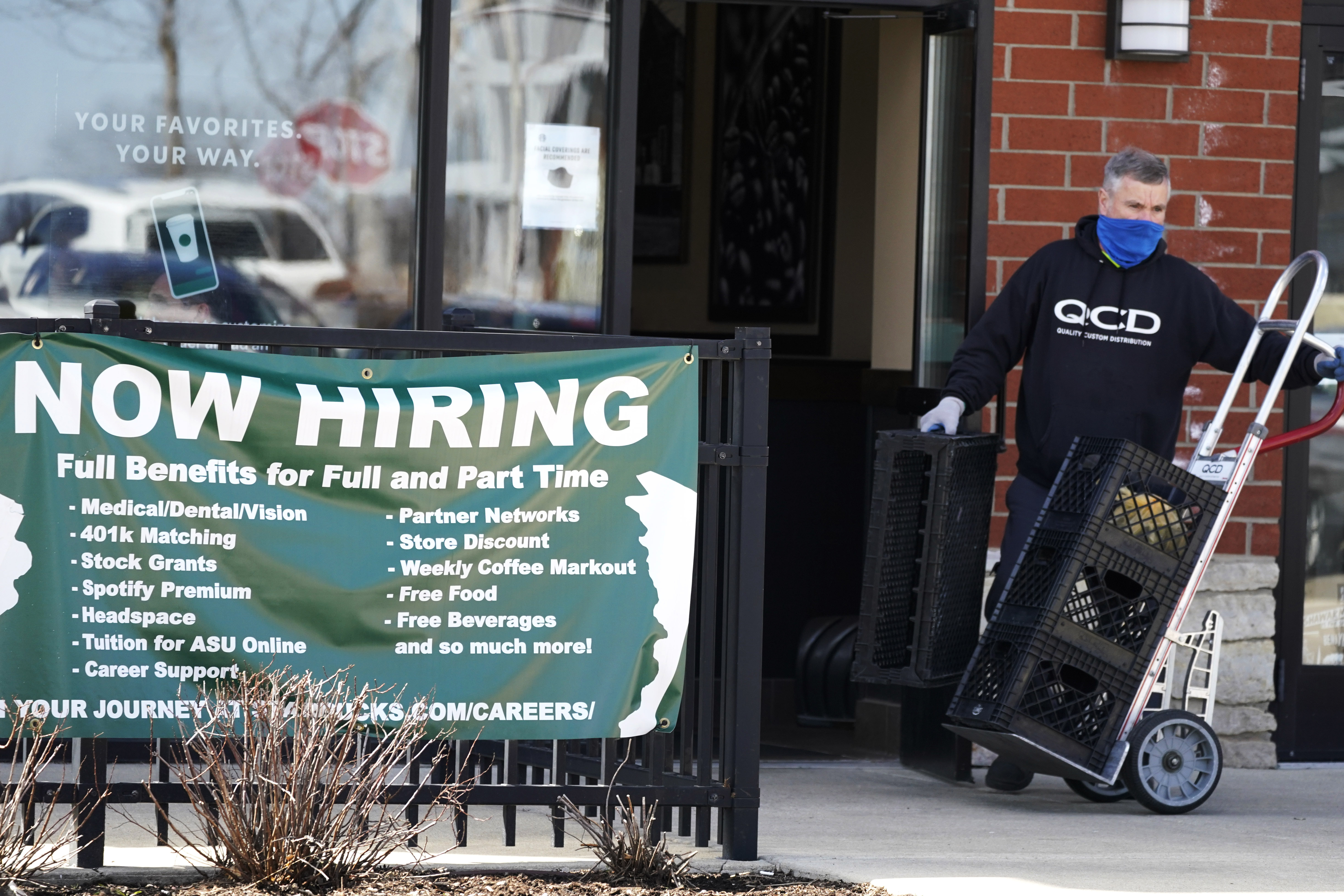A hiring sign is displayed outside of a Starbucks in Schaumburg, Ill