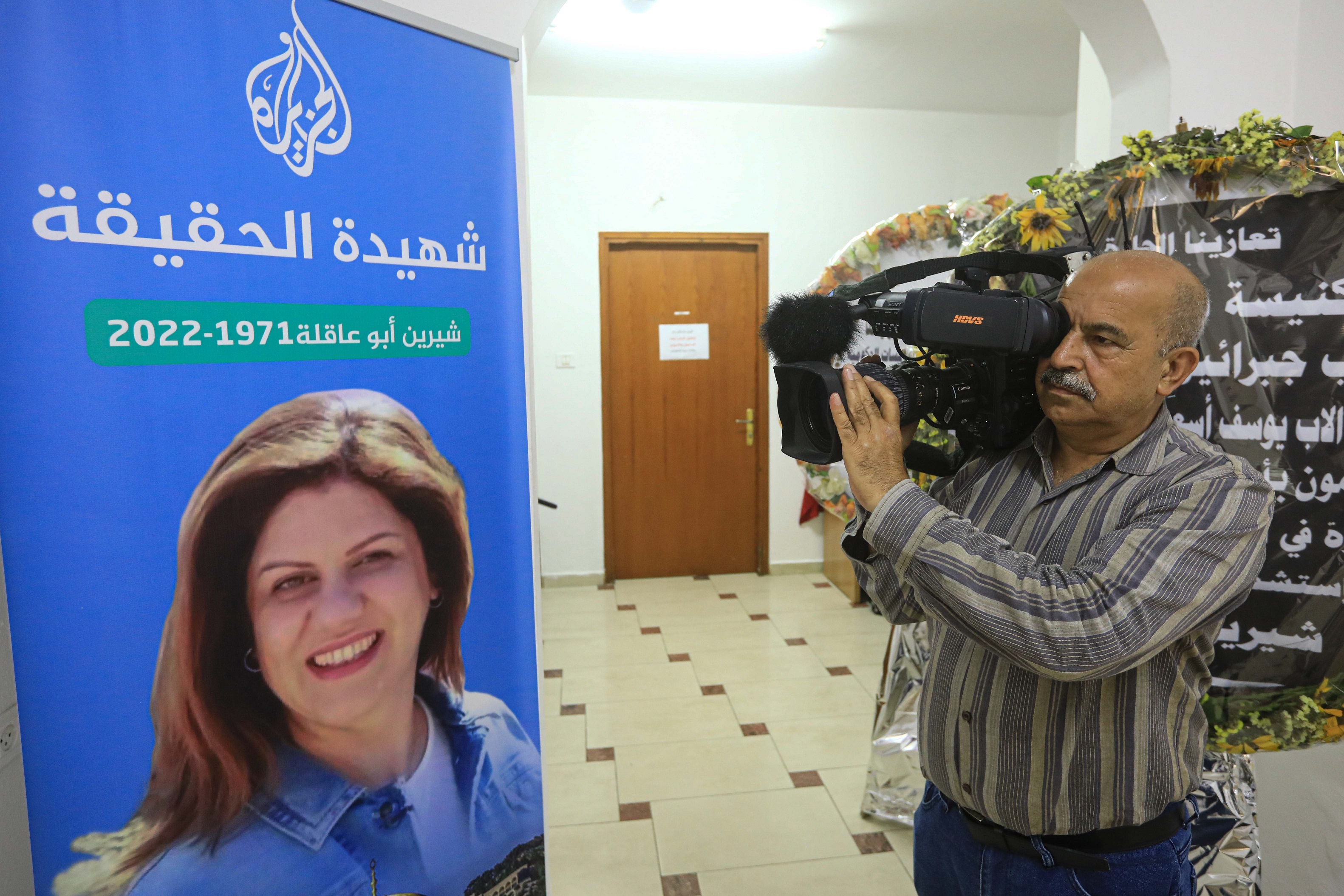 Al Jazeera cameraman Mahmoud Obaid shoots video of Shireen Abu Akleh’s memorial photo
