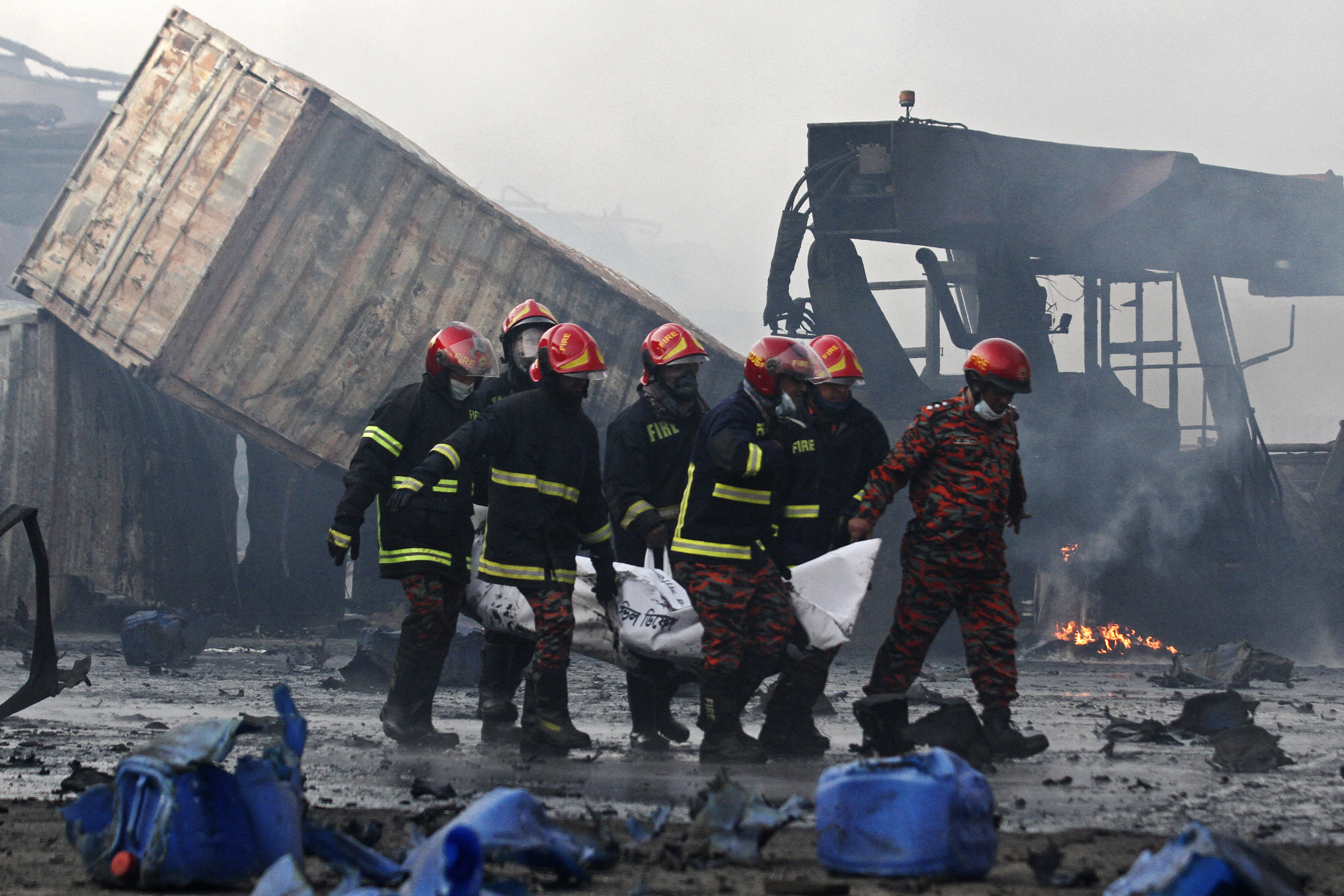 Firefighters carry the dead body of a victim
