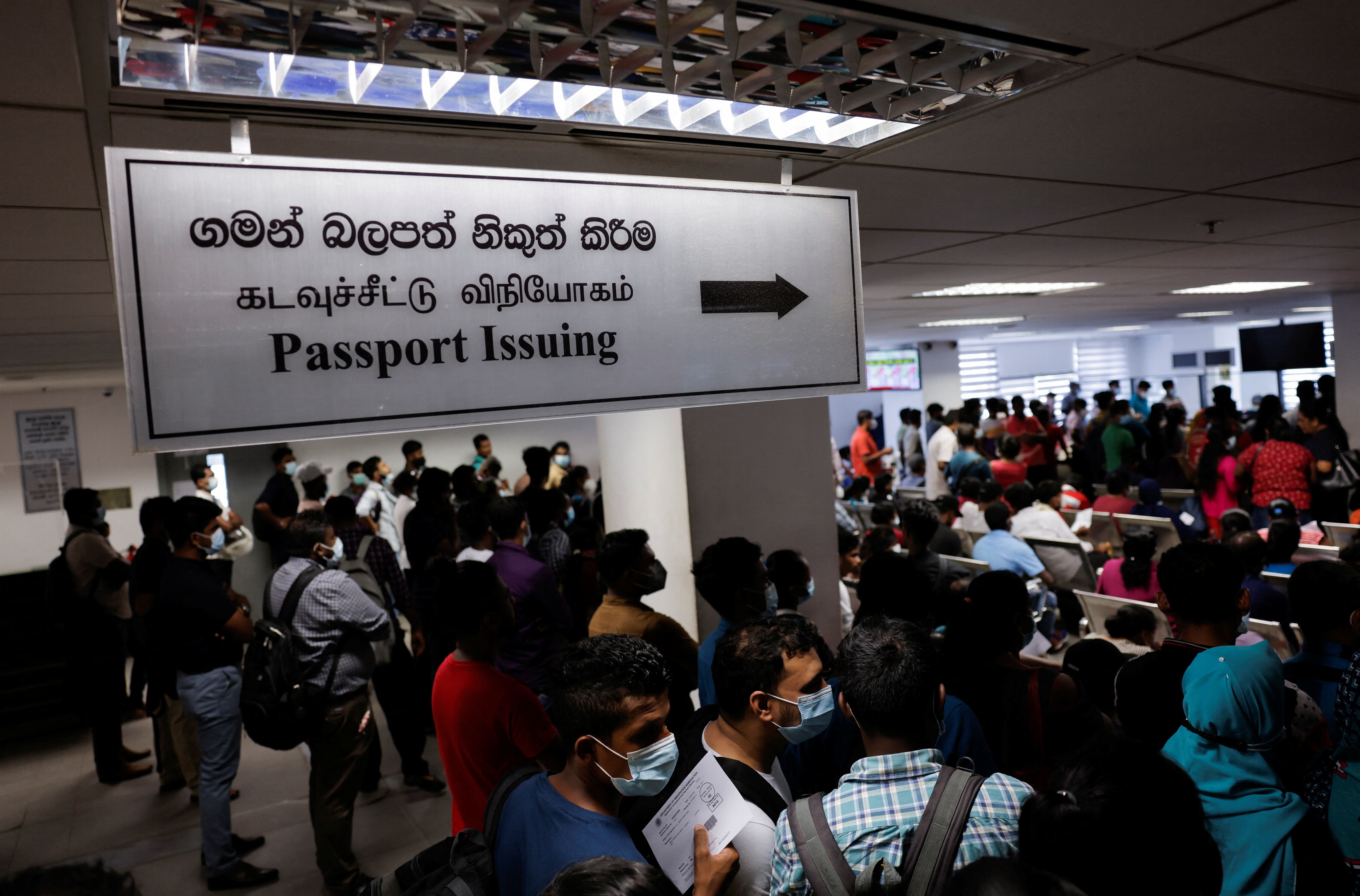 People wait to collect their passports