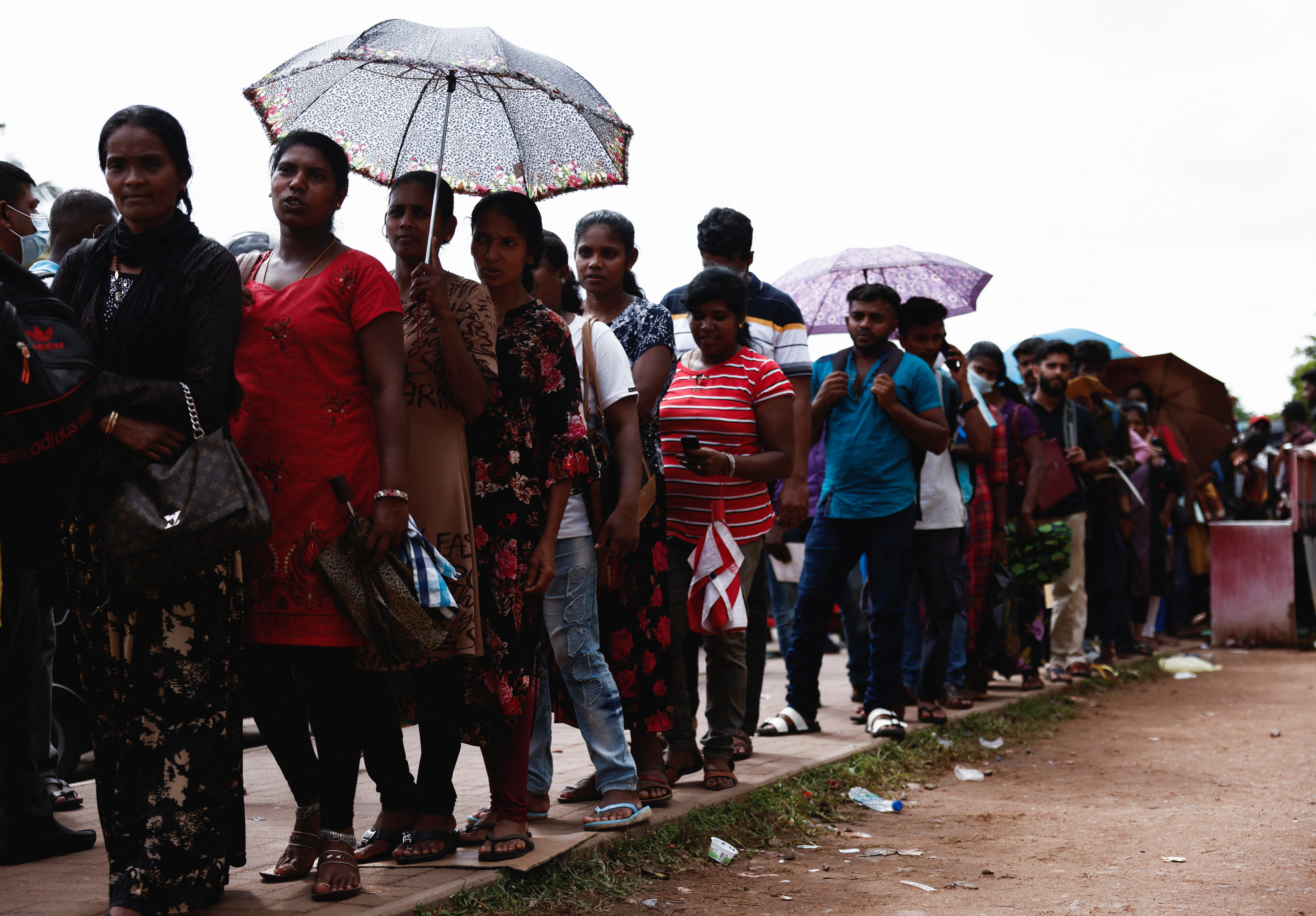People wait to apply for a passport