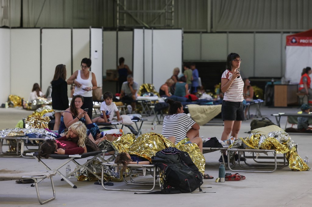 Holidaymakers at France's Dune du Pilat campsite lie in survival blankets after being evacuated