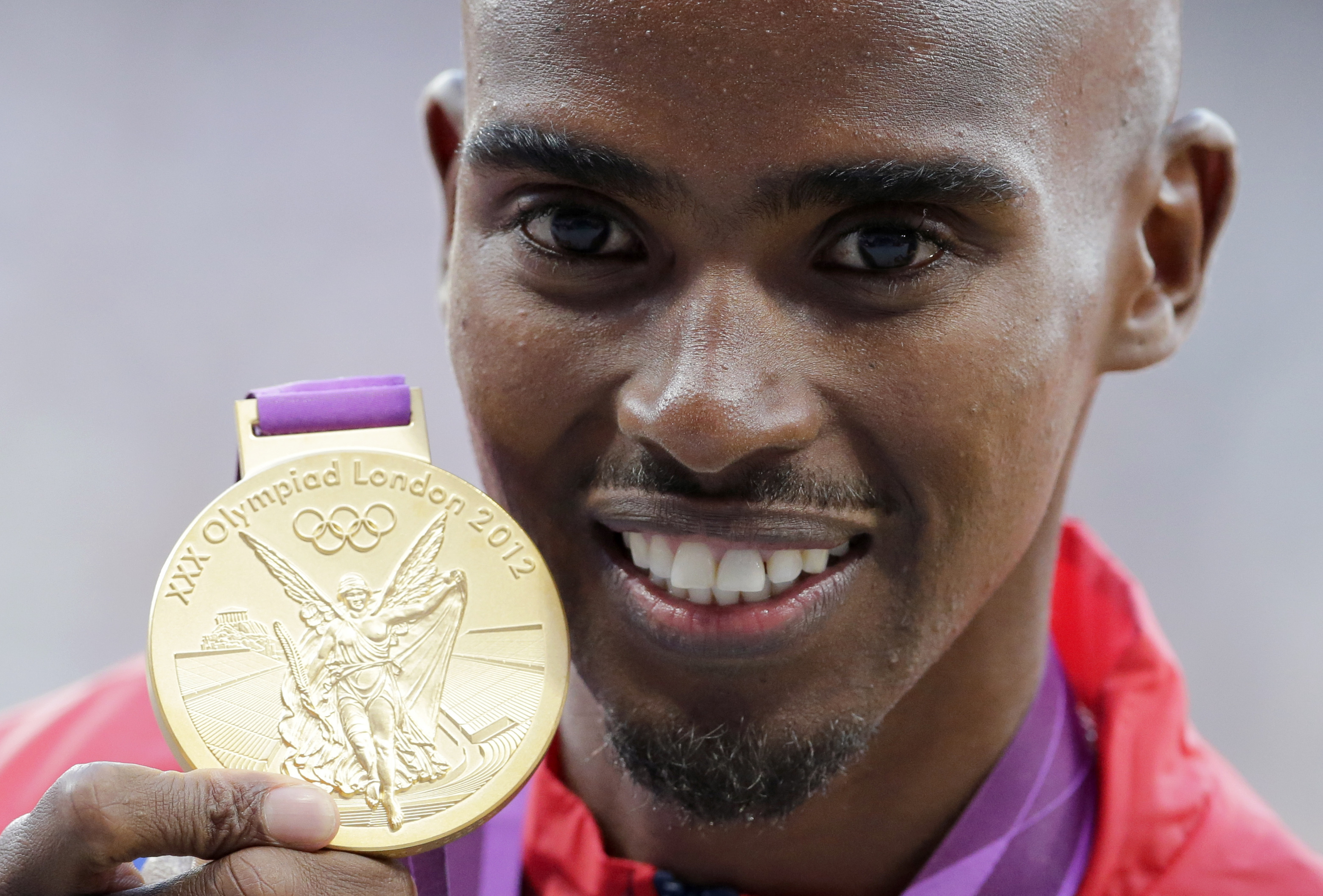 Britain's Mo Farah poses with his gold medal