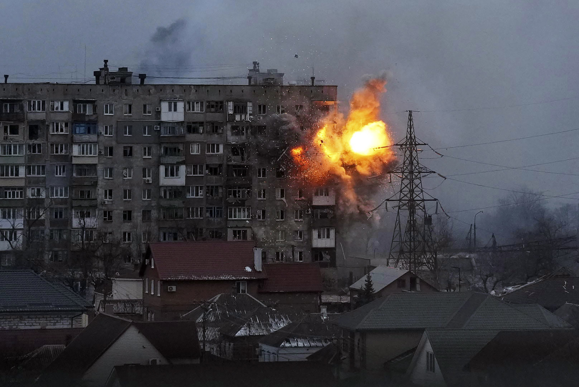 FILE - An explosion tears a hole in the side of an apartment building after a Russian tank fired a rocket in Mariupol, Ukraine, on March 11, 2022. Ukraine’s parliamentary commission on human rights says Russia's military has destroyed almost 38,000 residential buildings, rendering about 220,000 people homeless, in the 100 days since its invasion of Ukraine.
