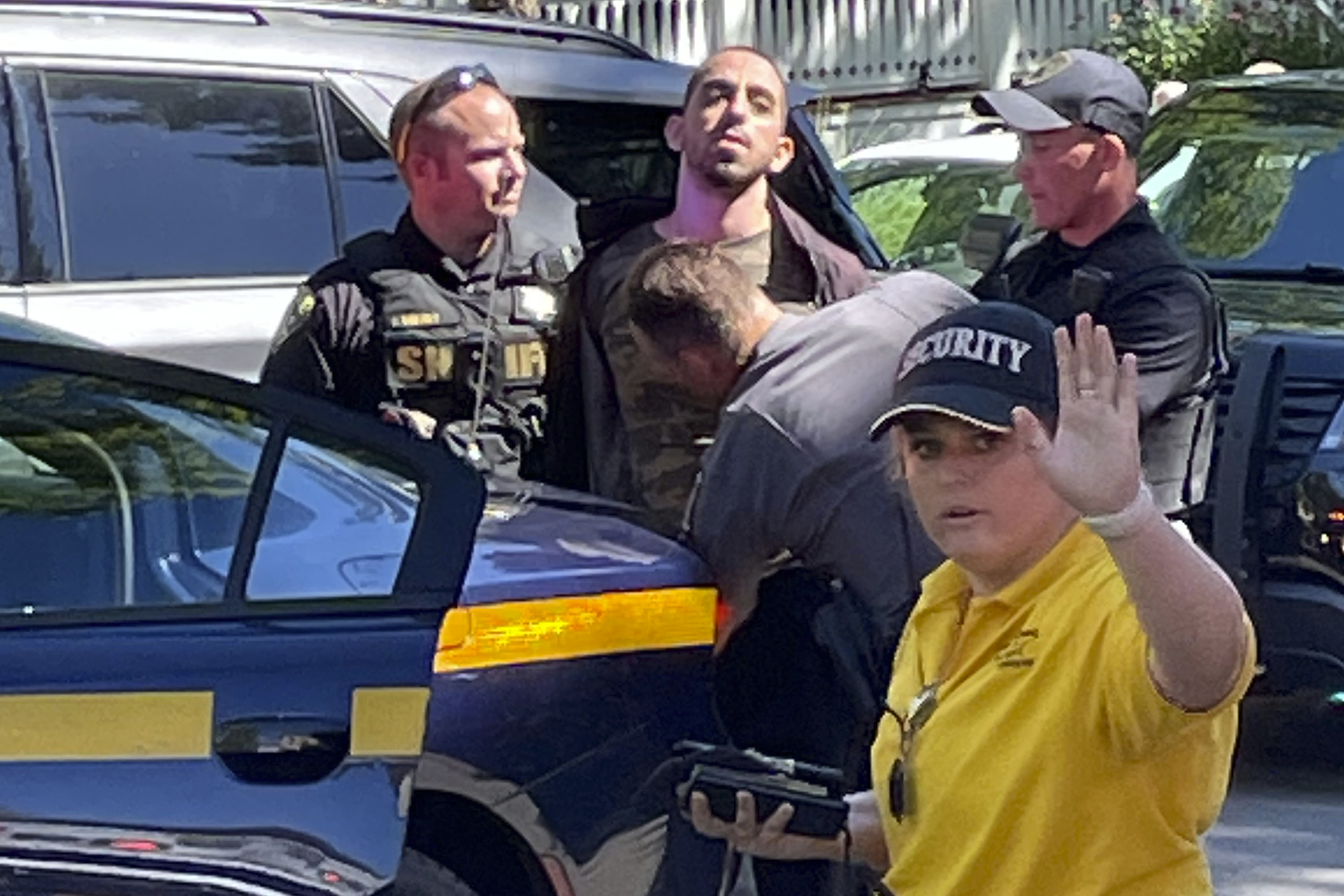 Law enforcement officers detain Hadi Matar, 24 and take him to a police car outside the Chautauqua Institution