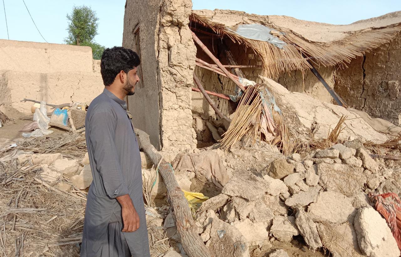 Naimatullah stands outside his collapsed house in Gandawa, Jhal Magsi district, Balochistan