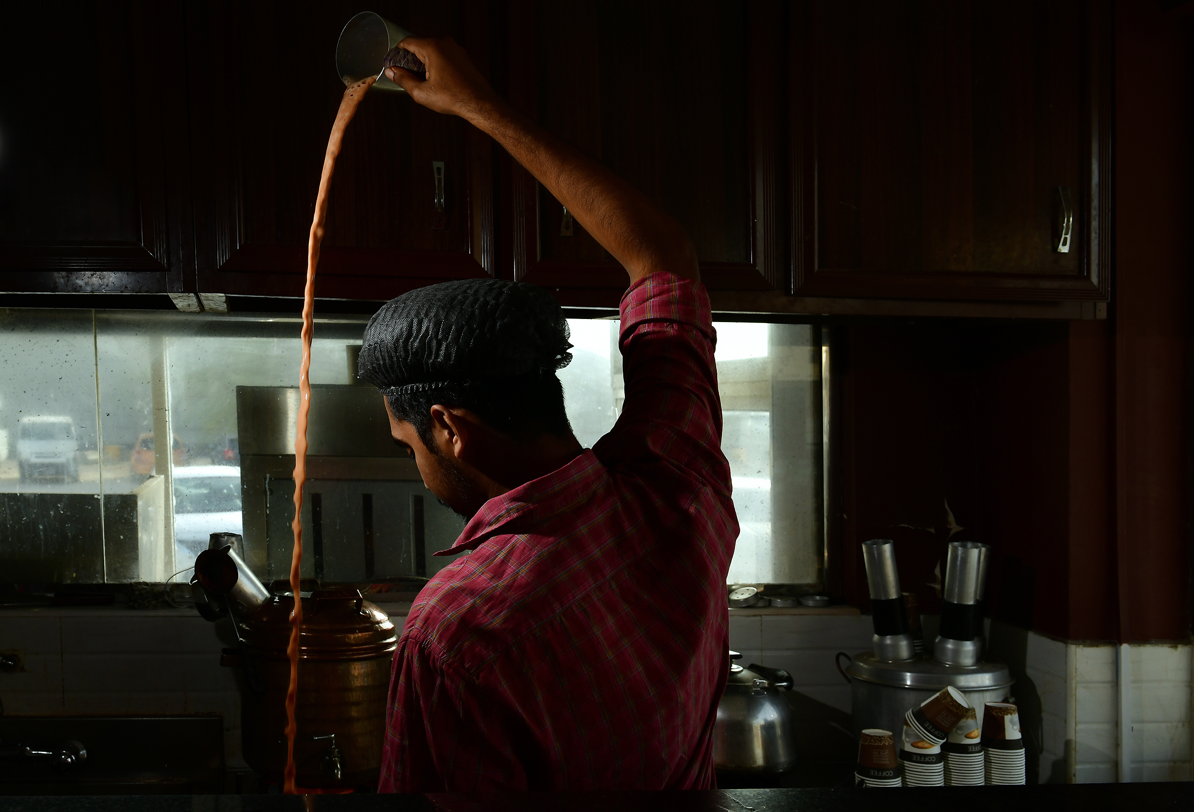 Teamaker Salman beats samovar tea to make a foam in the top layer