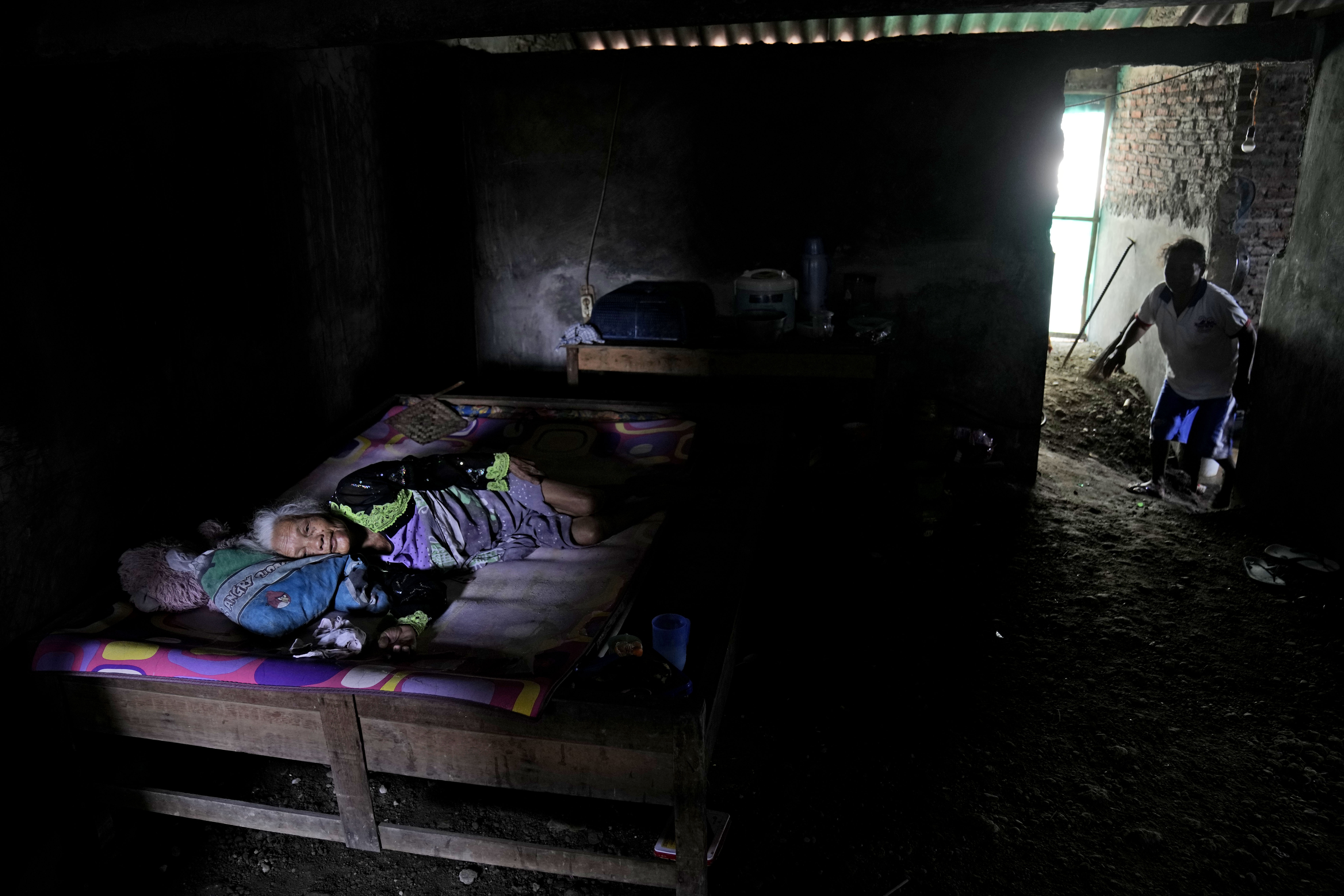 Suratmi, who is paralyzed, lies in her bed