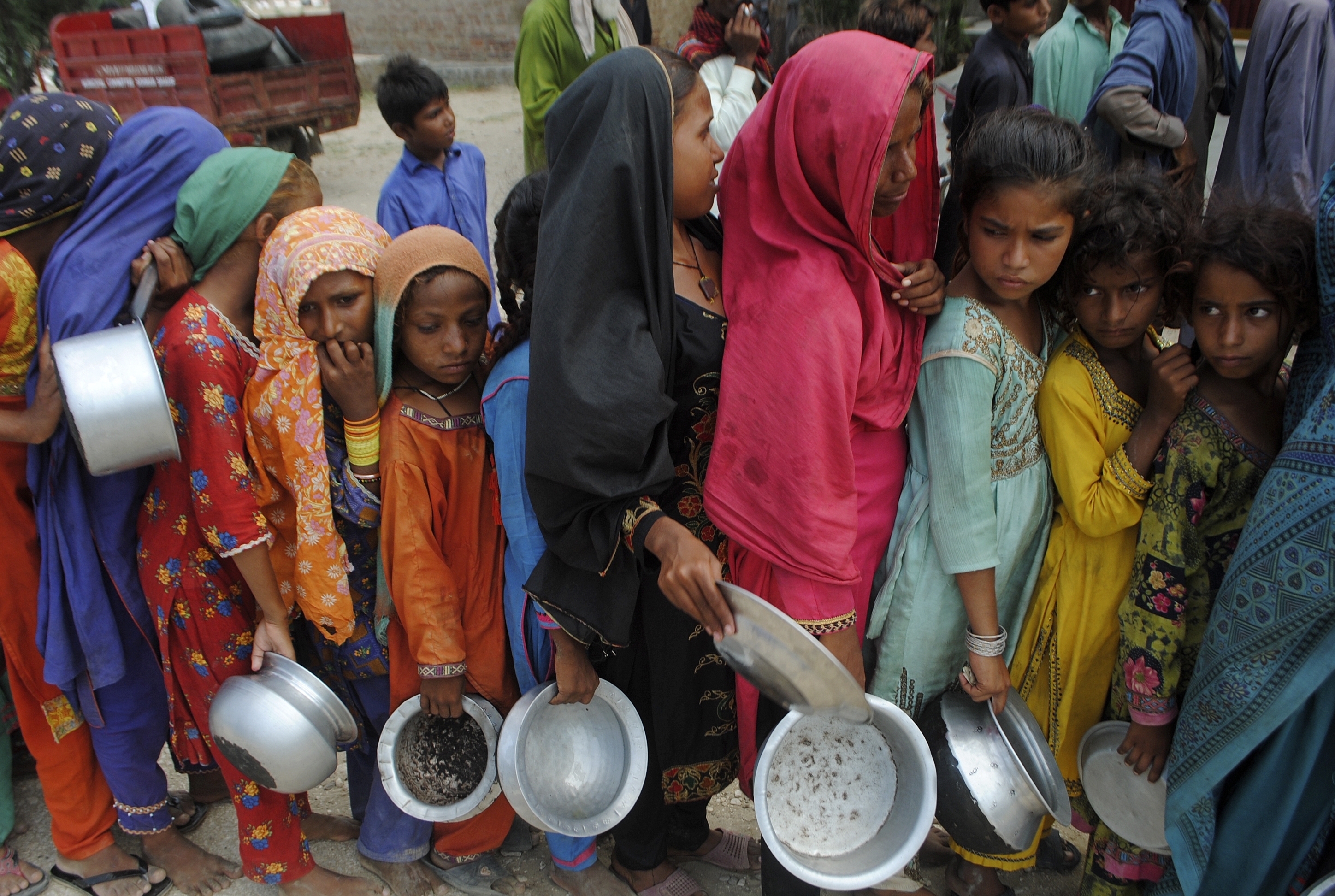 People from flood-affected areas wait to receive food distributed by the Saylani Welfare Trust, in Lal Bagh, Sindh province.