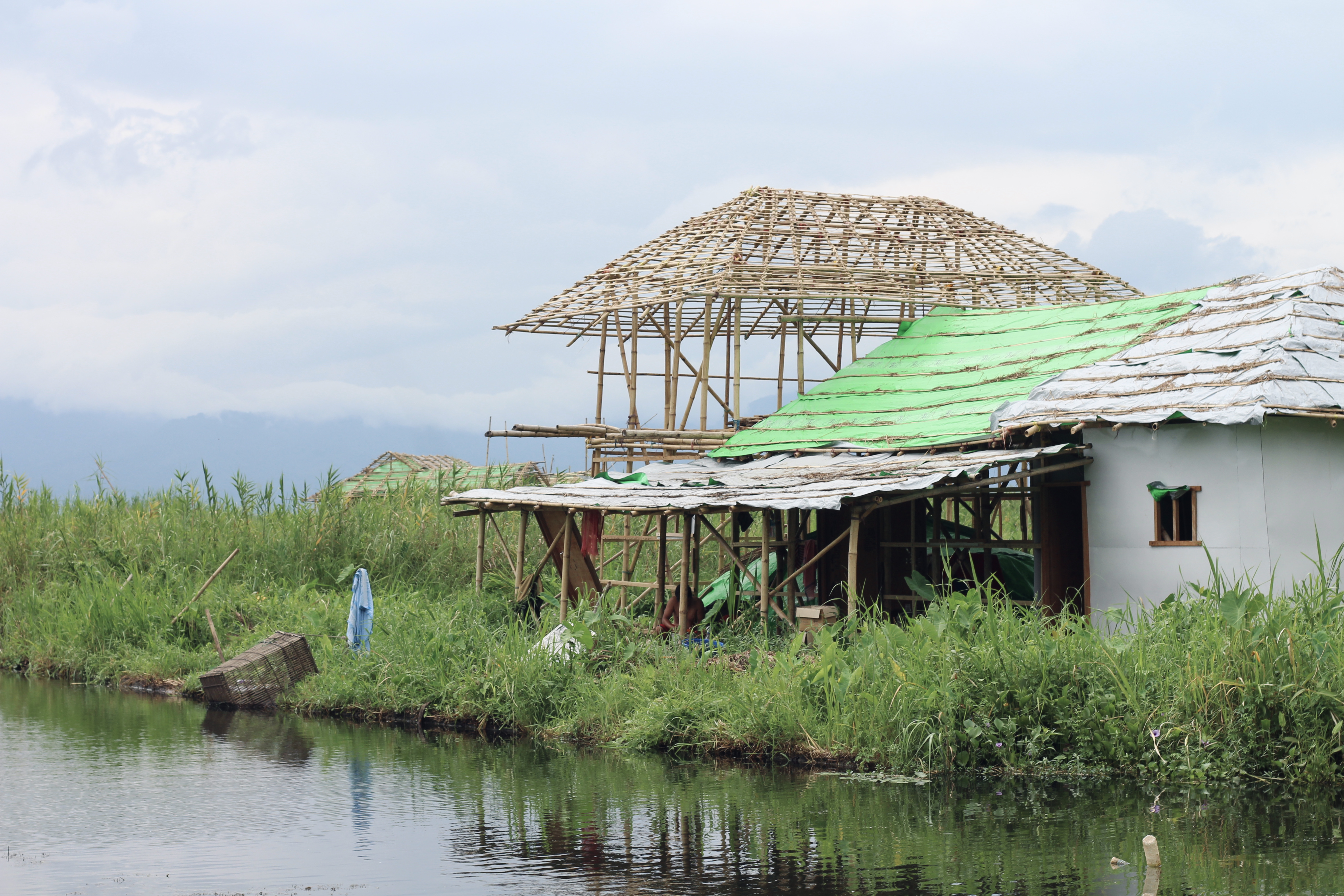 A floating homestay being dismantled by its owner. They are made of bamboo and grass or wood, and consist of one or two rooms