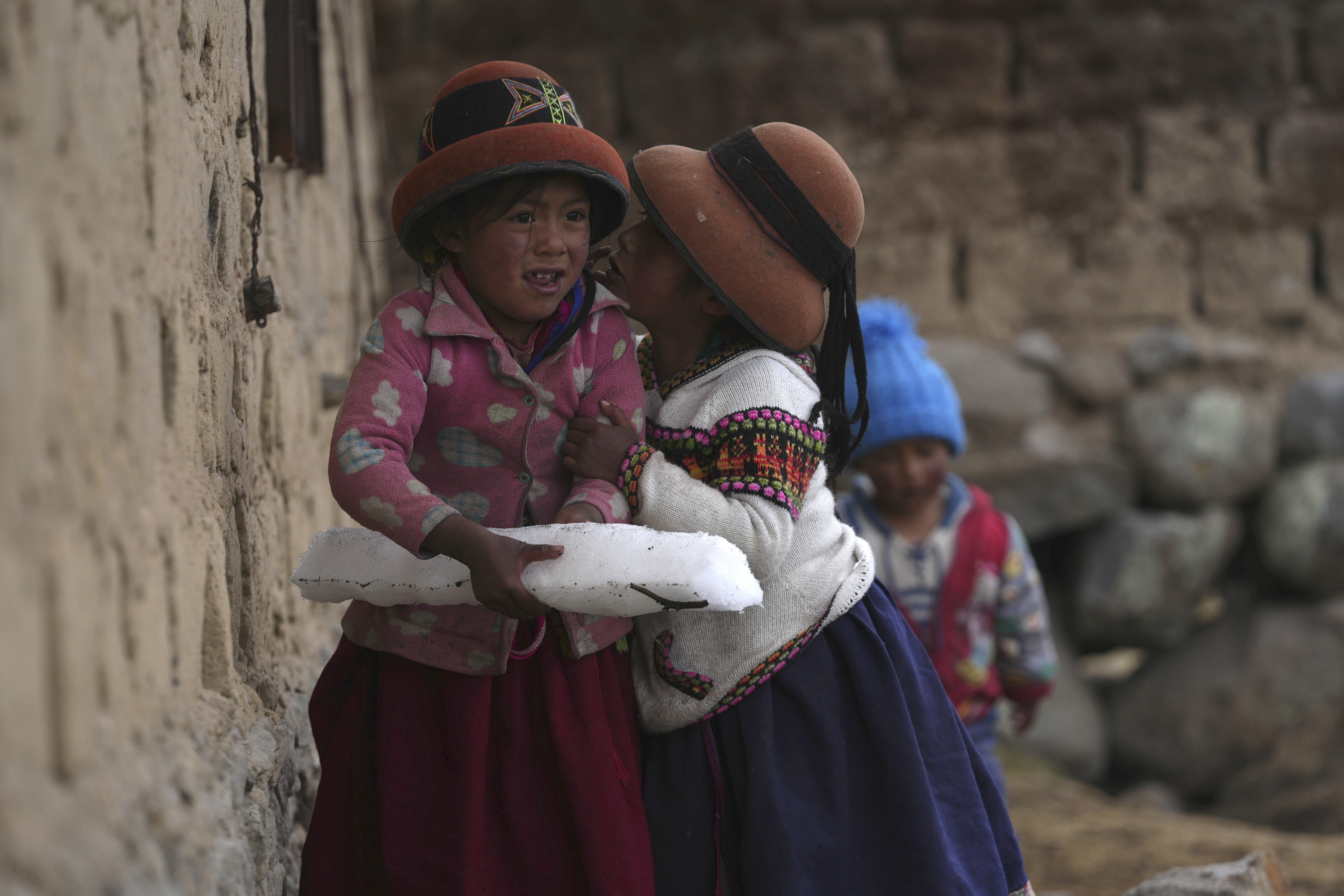 Girls play with a block of ice