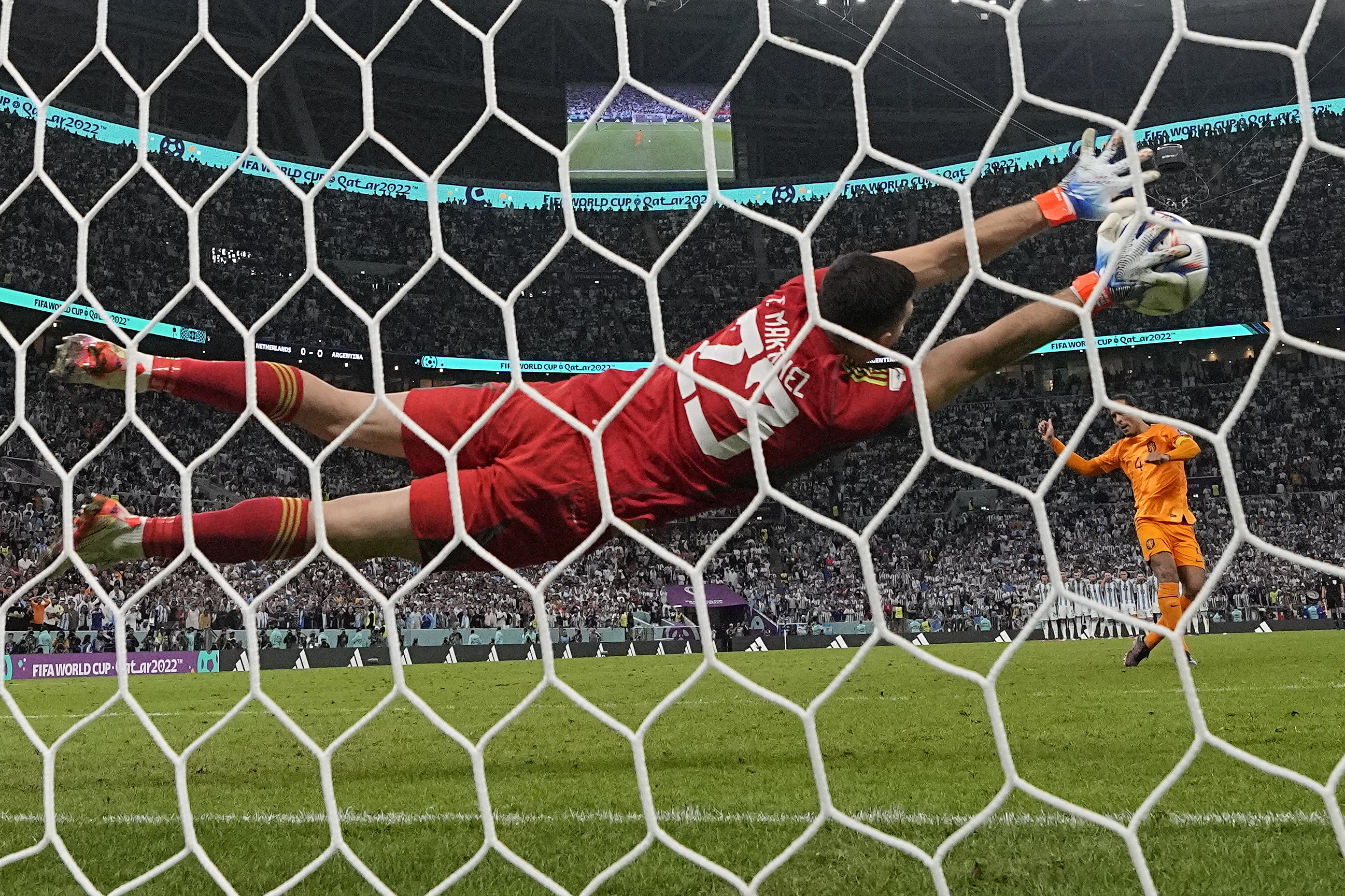Martinez lengthwise in mid-air with two arms outstretched, his hands on the ball