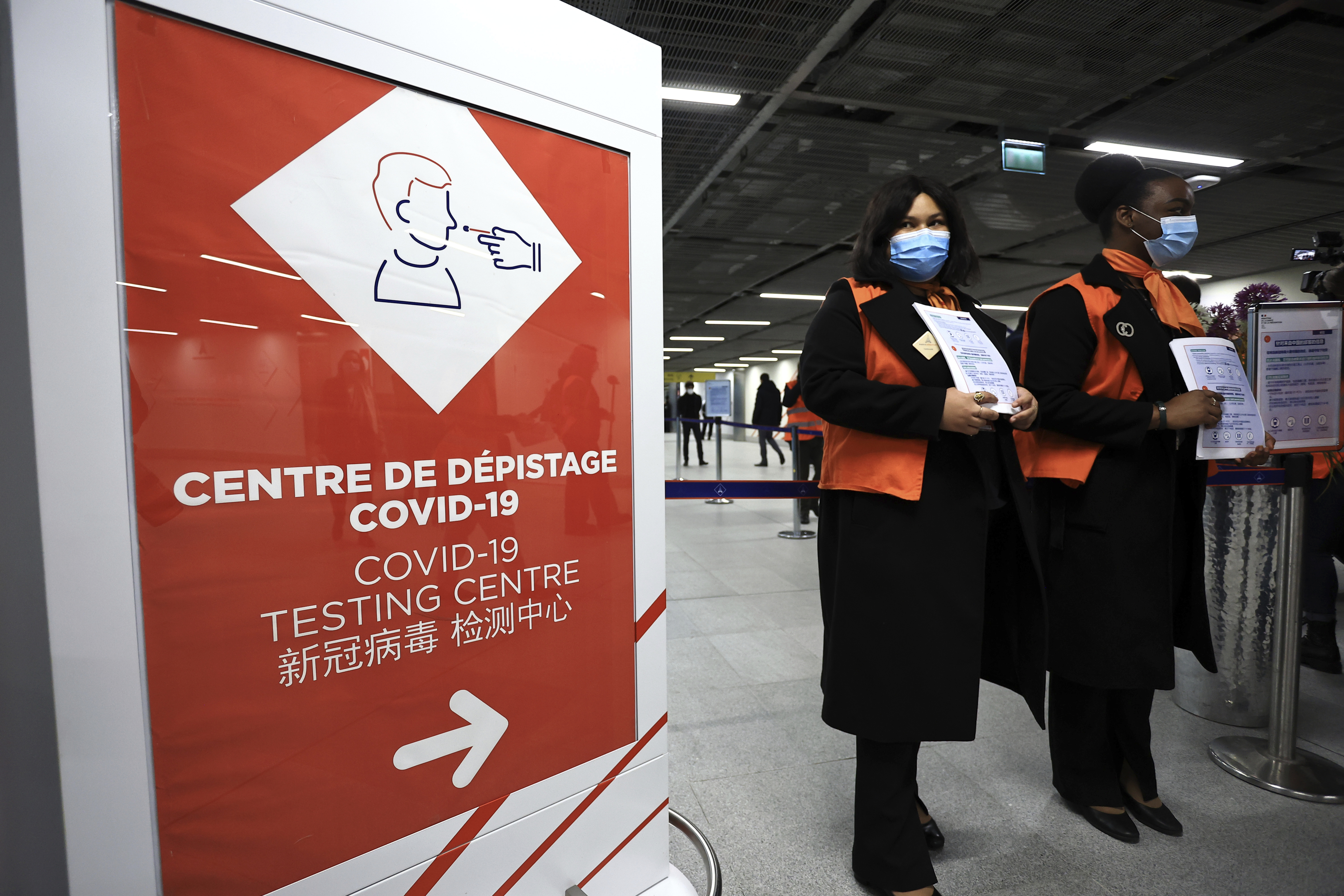 Airport staff wait from passengers coming from China in front of a COVID-19 testing area set at the Roissy Charles de Gaulle airport, north of Paris, Sunday, Jan. 1, 2023