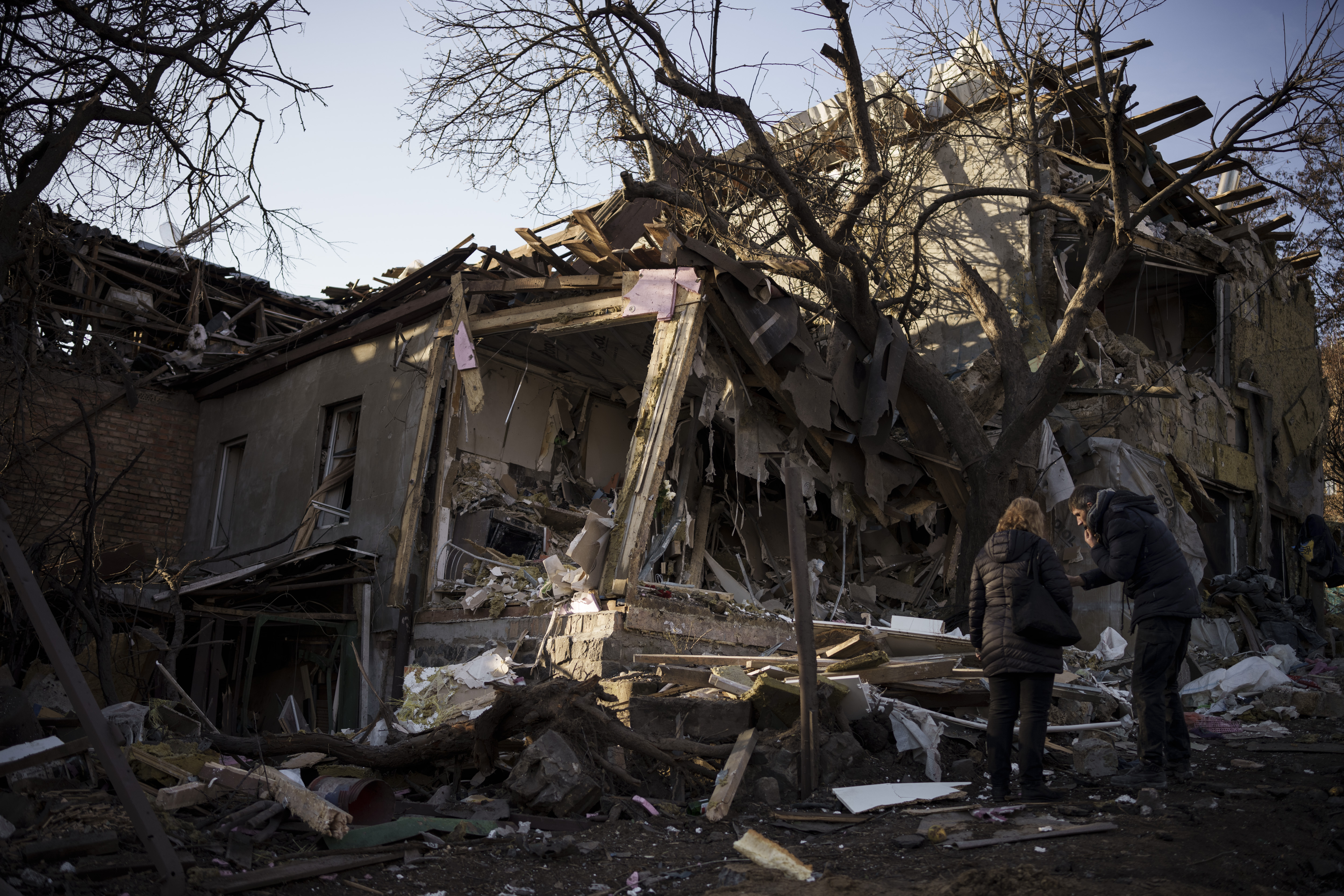 Serhii Kaharlytskyi, right, stands outside his home, destroyed after a Russian attack in Kyiv