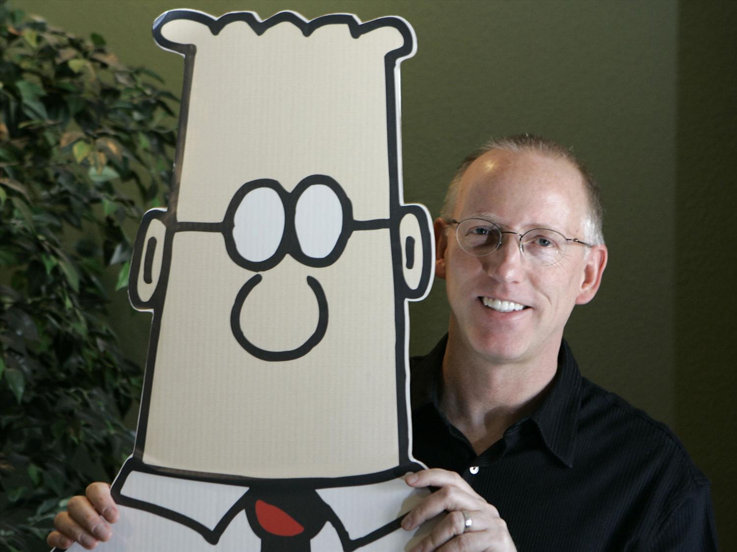 Scott Adams, creator of the "Dilbert" cartoon, poses with a large cutout of the Dilbert character.