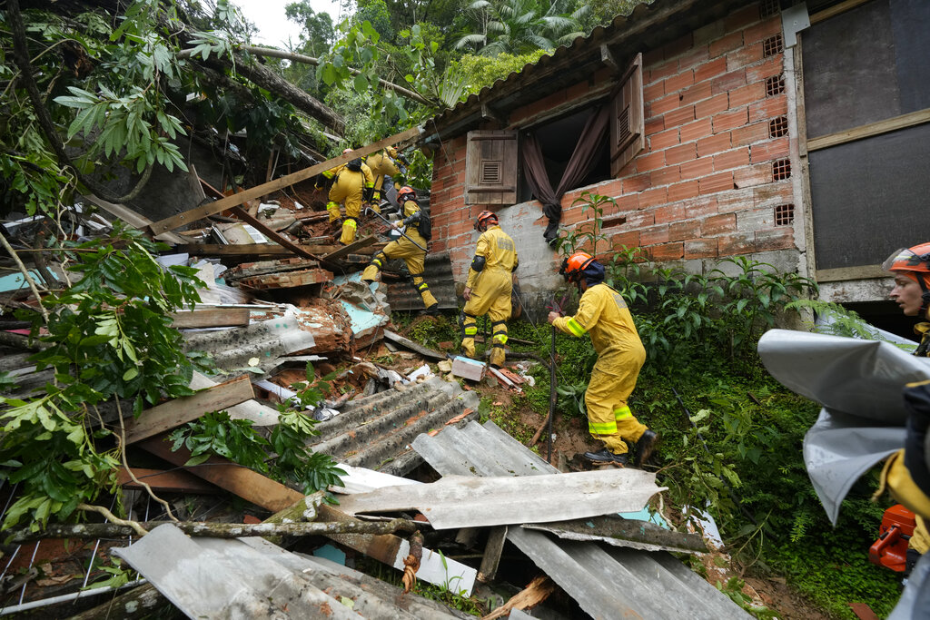Rescue workers search for survivors in amid wreckage caused by the floods