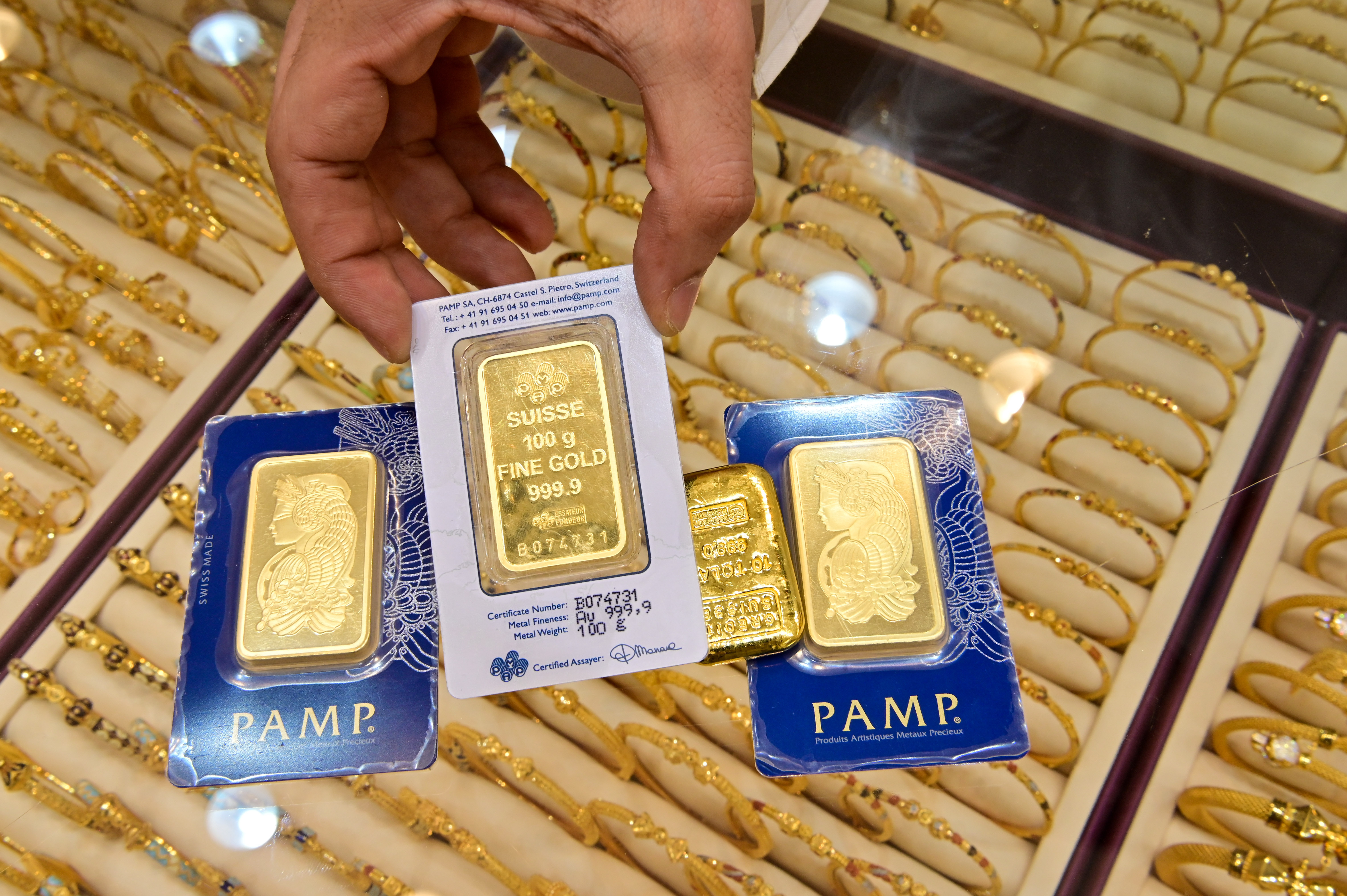 A man showing three bars of gold