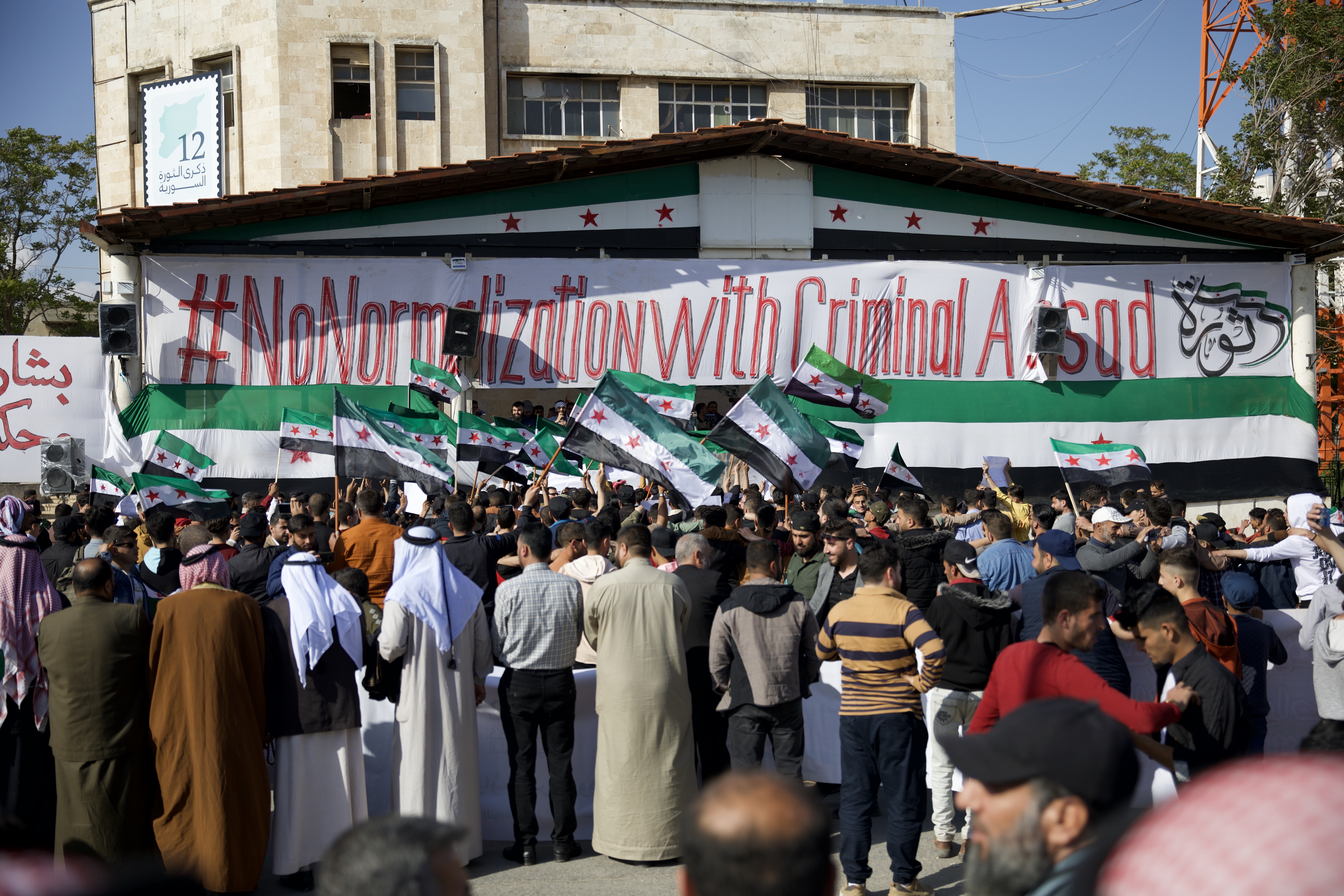 Protesters held signs, including one that read: ‘Whoever forgives and reconciles [with al-Assad] is a criminal traitor … and is like him’
